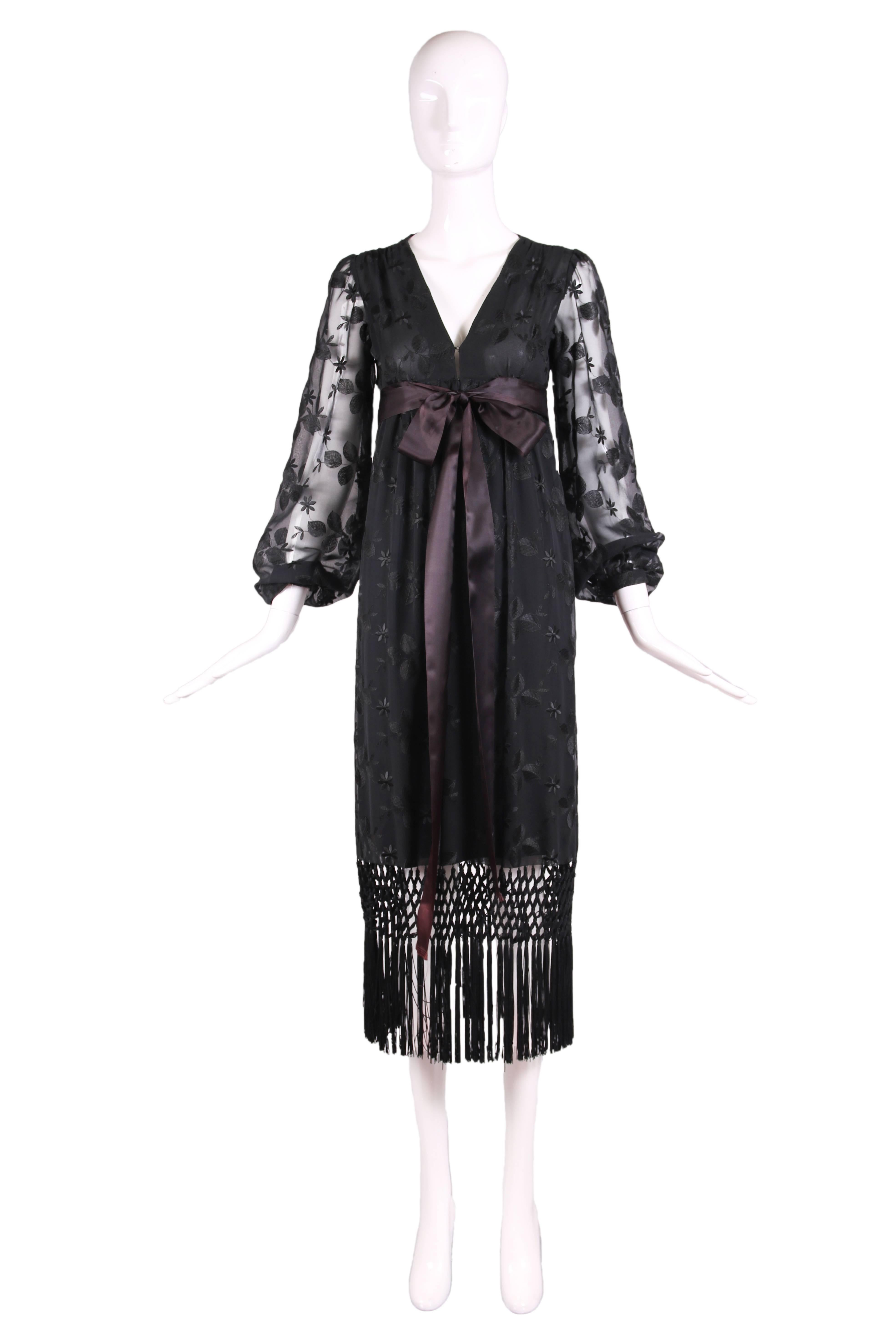 Vintage Givenchy haute couture black chiffon embroidered gown featuring macrame fringe detail and satin ribbon bow at empire waist. The dress has a V-neckline and sheer chiffon sleeves. Lined in black silk at bodice and bust is double-lined in sheer