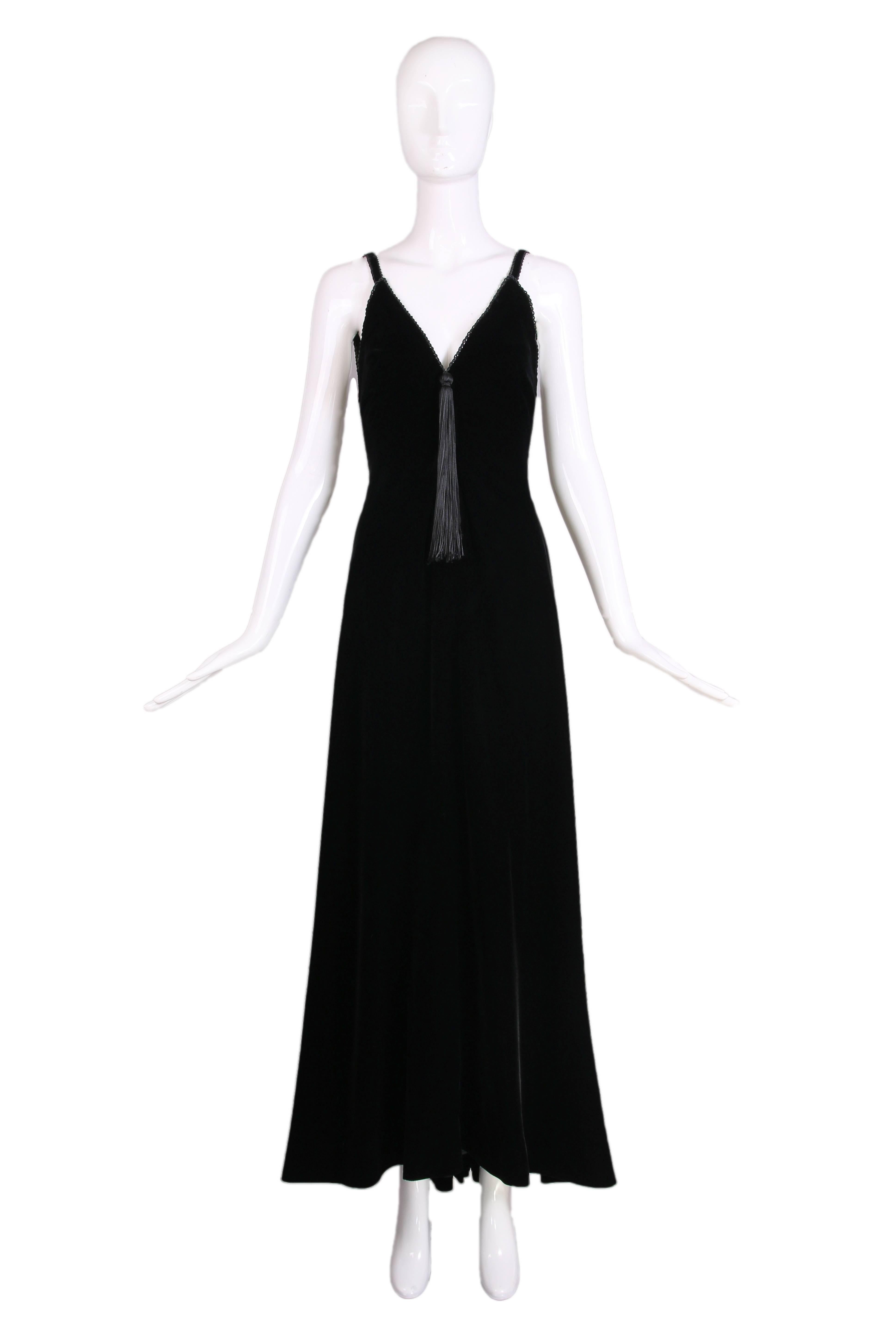 Stunning ca.1985 Givenchy haute couture black silk velvet evening gown with a V-neckline that features braided silk trim and a single tassel that hangs at the V. The gown has an open back that culminates in a V, also with a single tassel and there