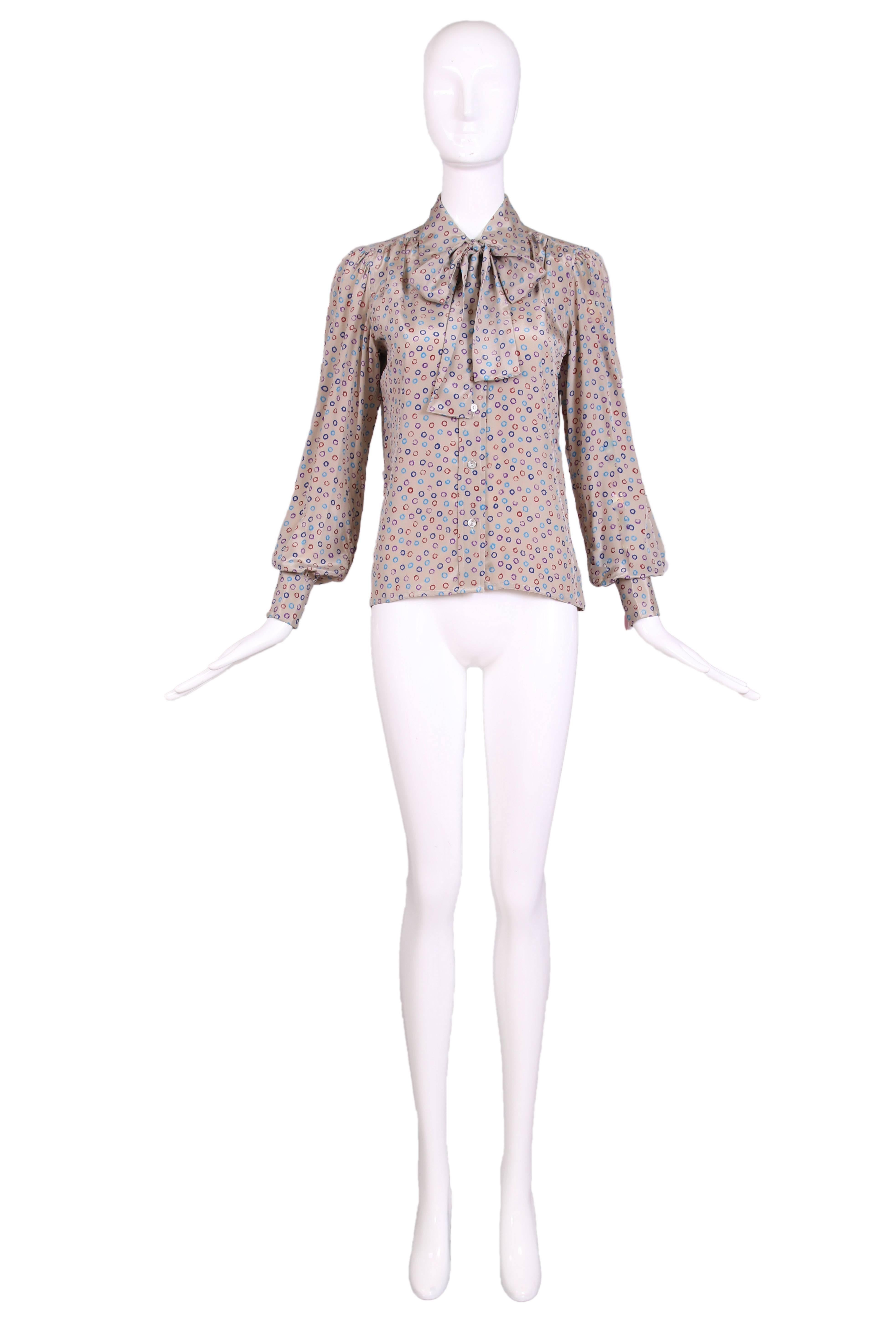 1970's Yves Saint Laurent silk blouse with pale gray background with multi-colored circle print . Features pussy blow, button closures up the front. In excellent condition with two small marks on one sleeve. Seize 38.
MEASUREMENTS:
Bust -