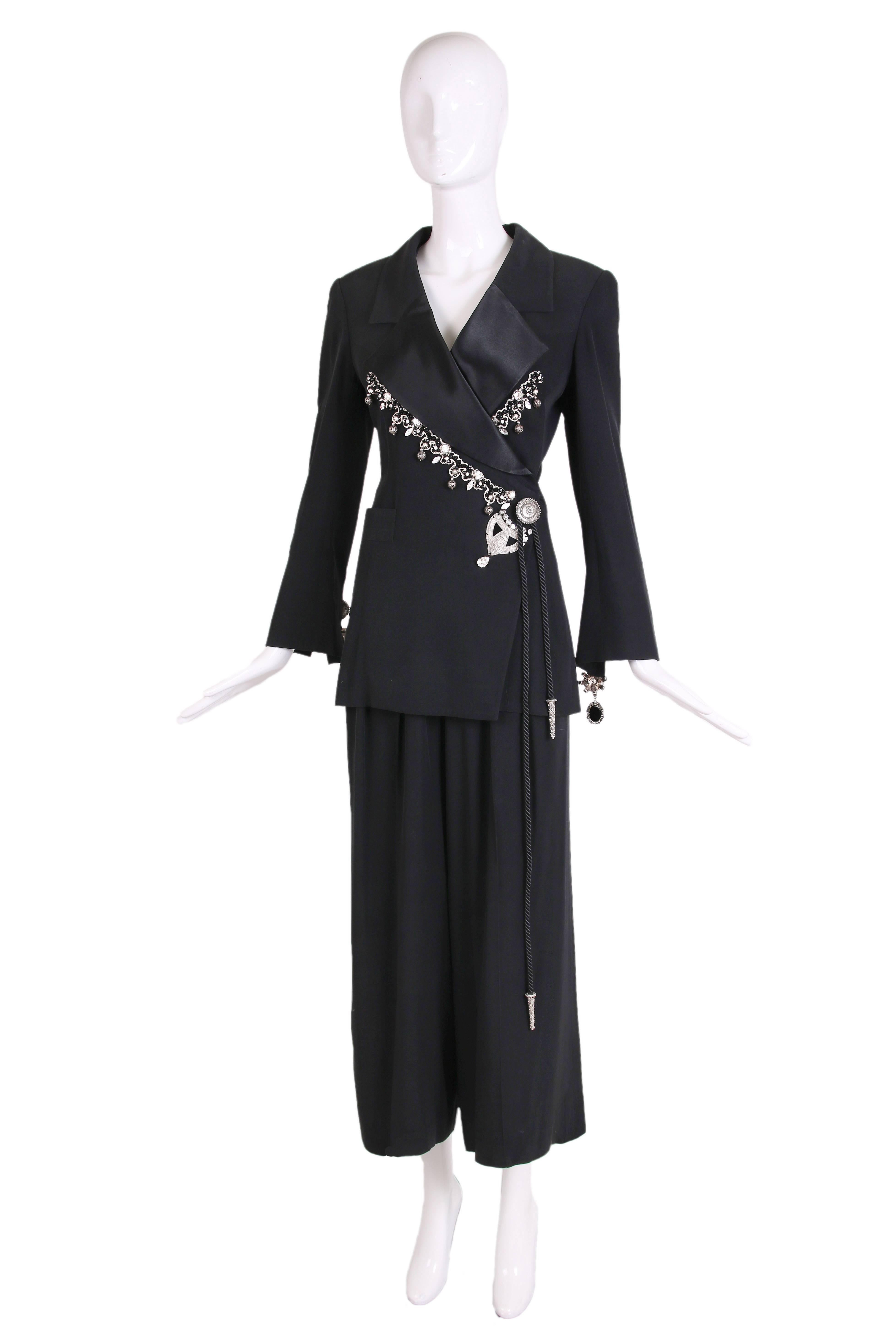 1994 Christian Dior by Gianfranco Ferre black tuxedo wrap jacket with metal and rhinestone embellishments as well as attached silk cord wrap at waist and high-waisted, pleated matching pants. In excellent condition. Jacket is size 36 and pants are a
