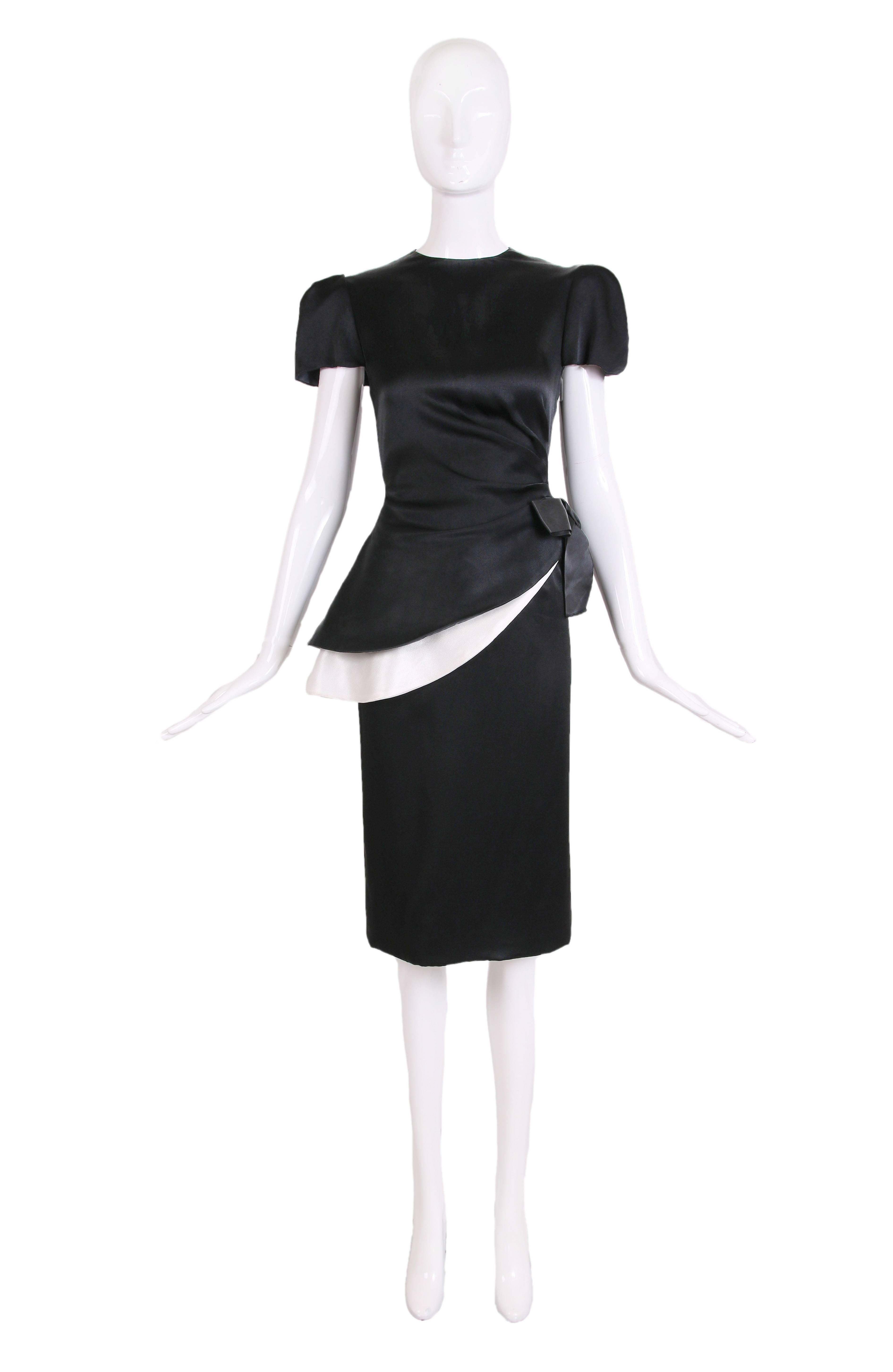 1970's Bill Blass black and white asymmetric silk blouse w/silk bow at side and two matching pencil skirts - one black and one white. The blouse has a high neckline, structured cap sleeves, and two hidden zipper closures - one at the side and one at