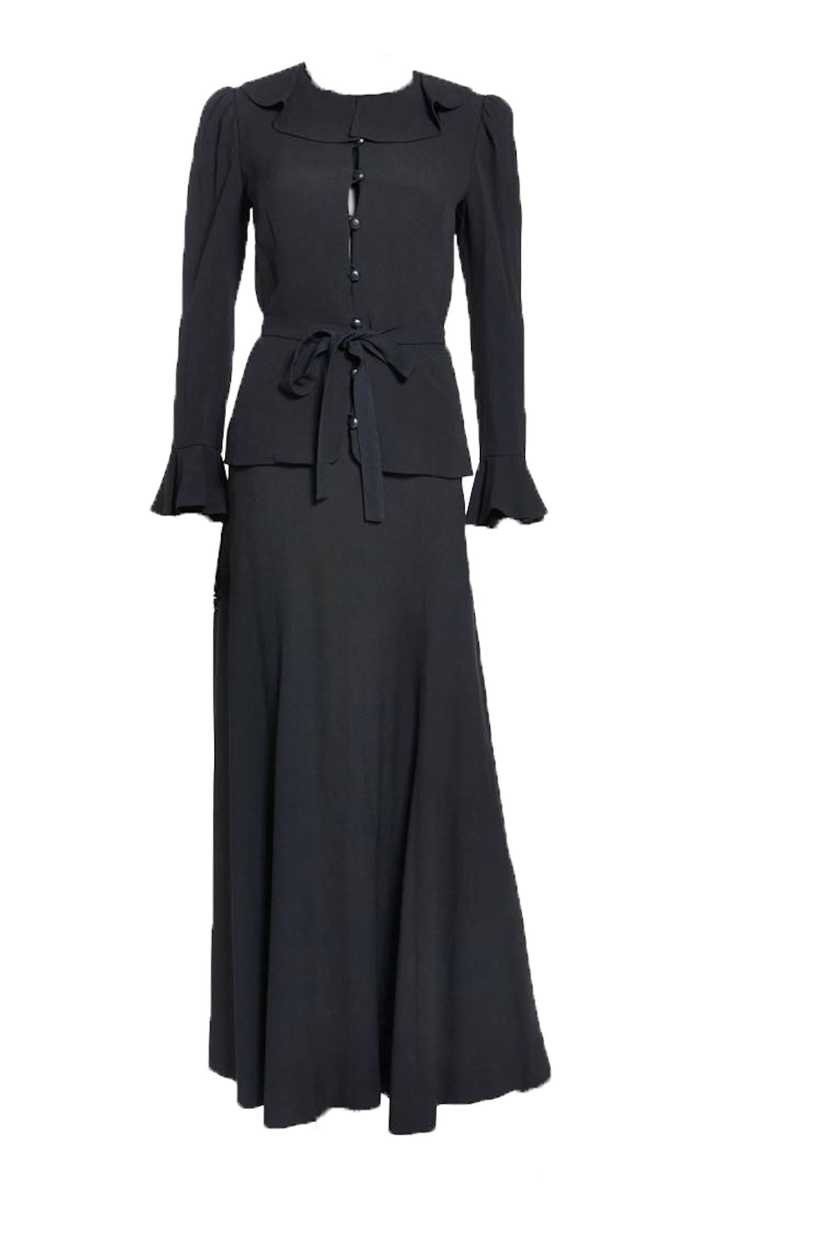 S/S 1974 Yves Saint Laurent black crepe 2-piece ensemble comprised of a ruffled trim front button closure blouse w/detachable belt and matching maxi-skirt. Attached is original editorial from 1974. In excellent condition. Both top and skirt are a FR