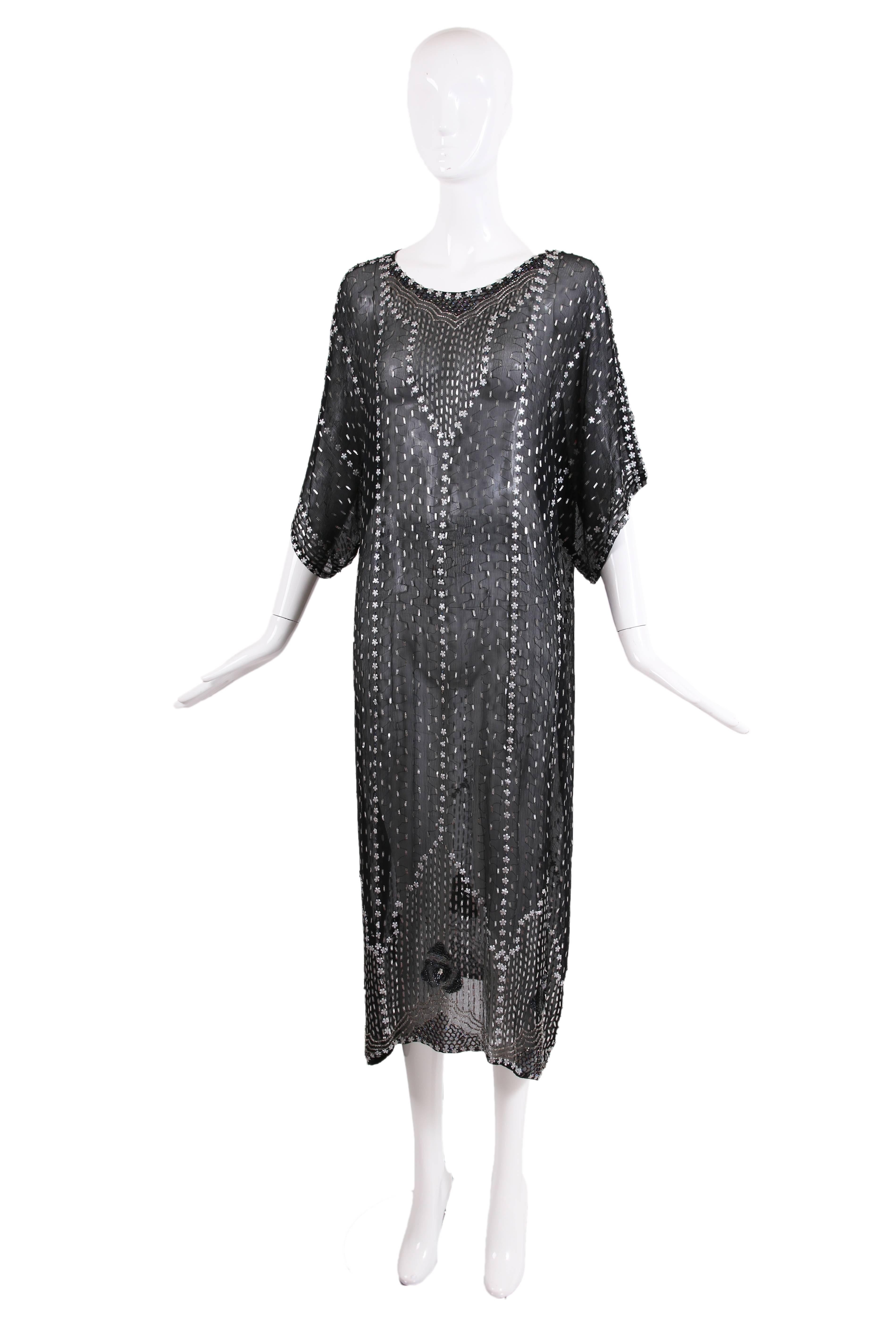 Vintage black silk sheer dress or caftan with beading and appliqués all over and sequined flowers at the hem. In very good to excellent condition with some missing beads at neckline. Will fit a variety of sizes due to shape.
MEASUREMENTS: 
47.5” long