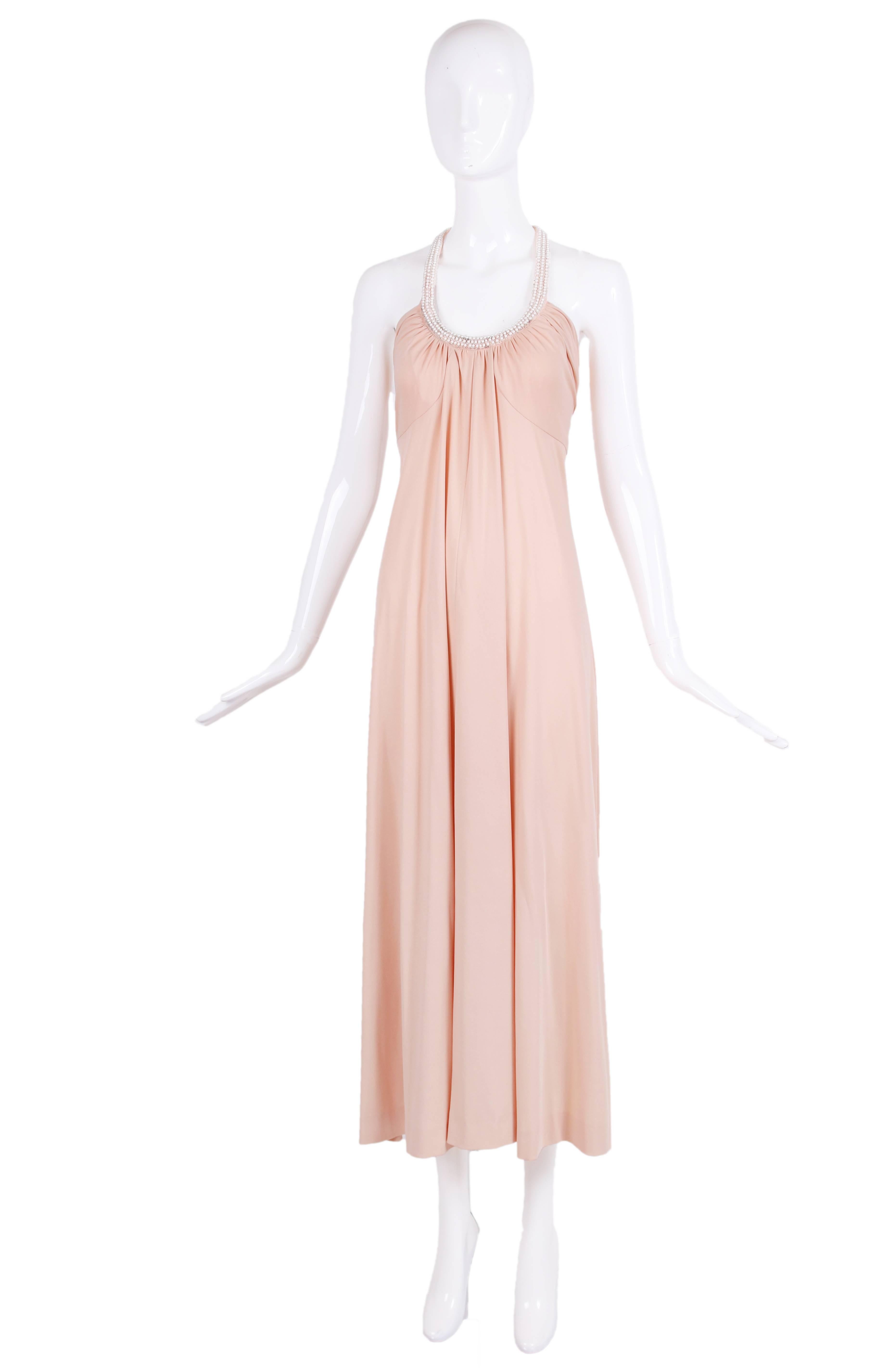 1970's Donald Brooks boutique blush pink jersey gown with pearl and beads decorating the halter neck. In excellent condition with some scattered missing beads - looks like someone might have removed the interior lining. No size tag - please consult