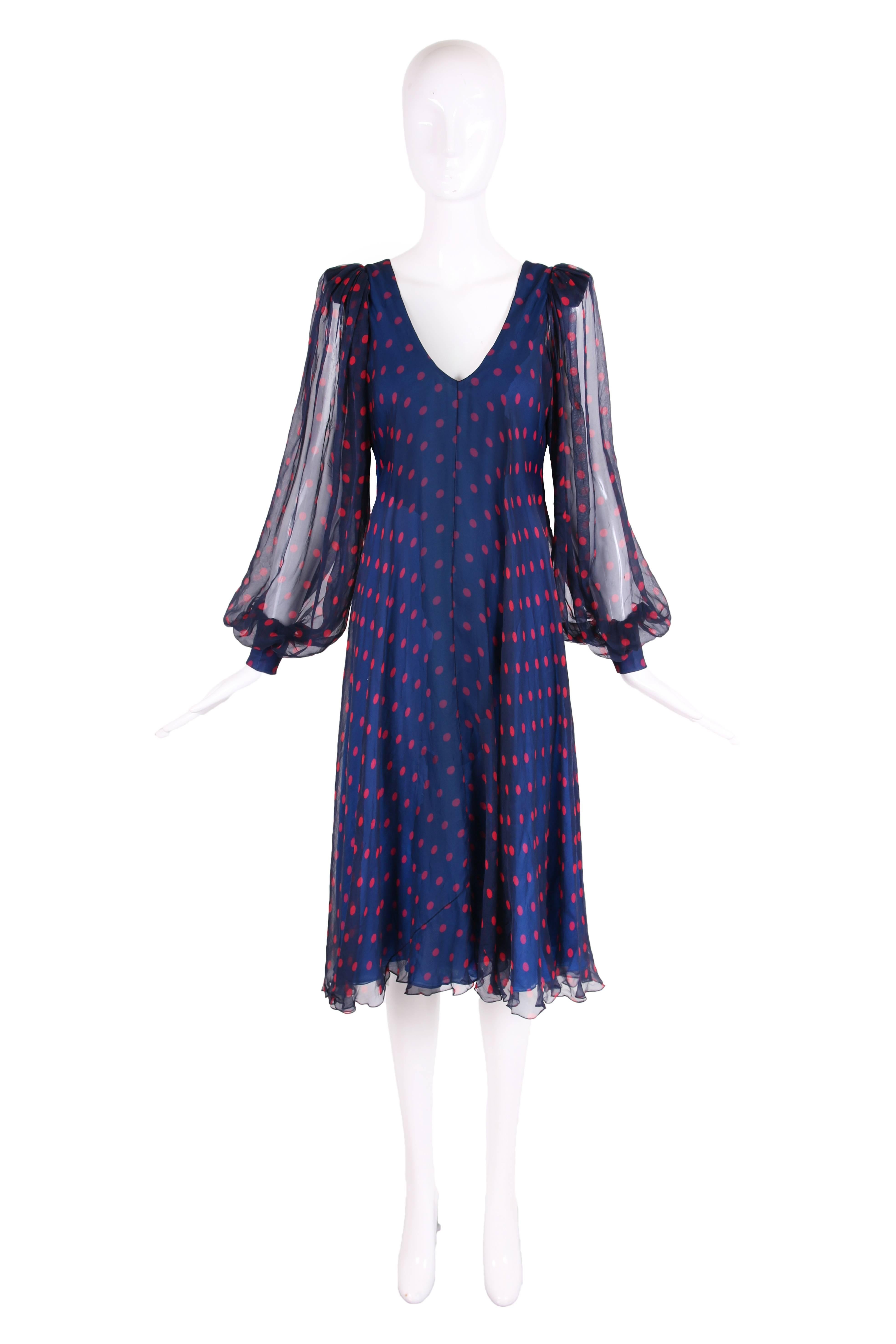 1970's Stavropoulos navy blue silk chiffon multi-layered cocktail dress with red polka-dots throughout. This dress is cut on the bias, has a V-neckline at front and back and features sheer over-sized balloon sleeves and three layers of bright blue