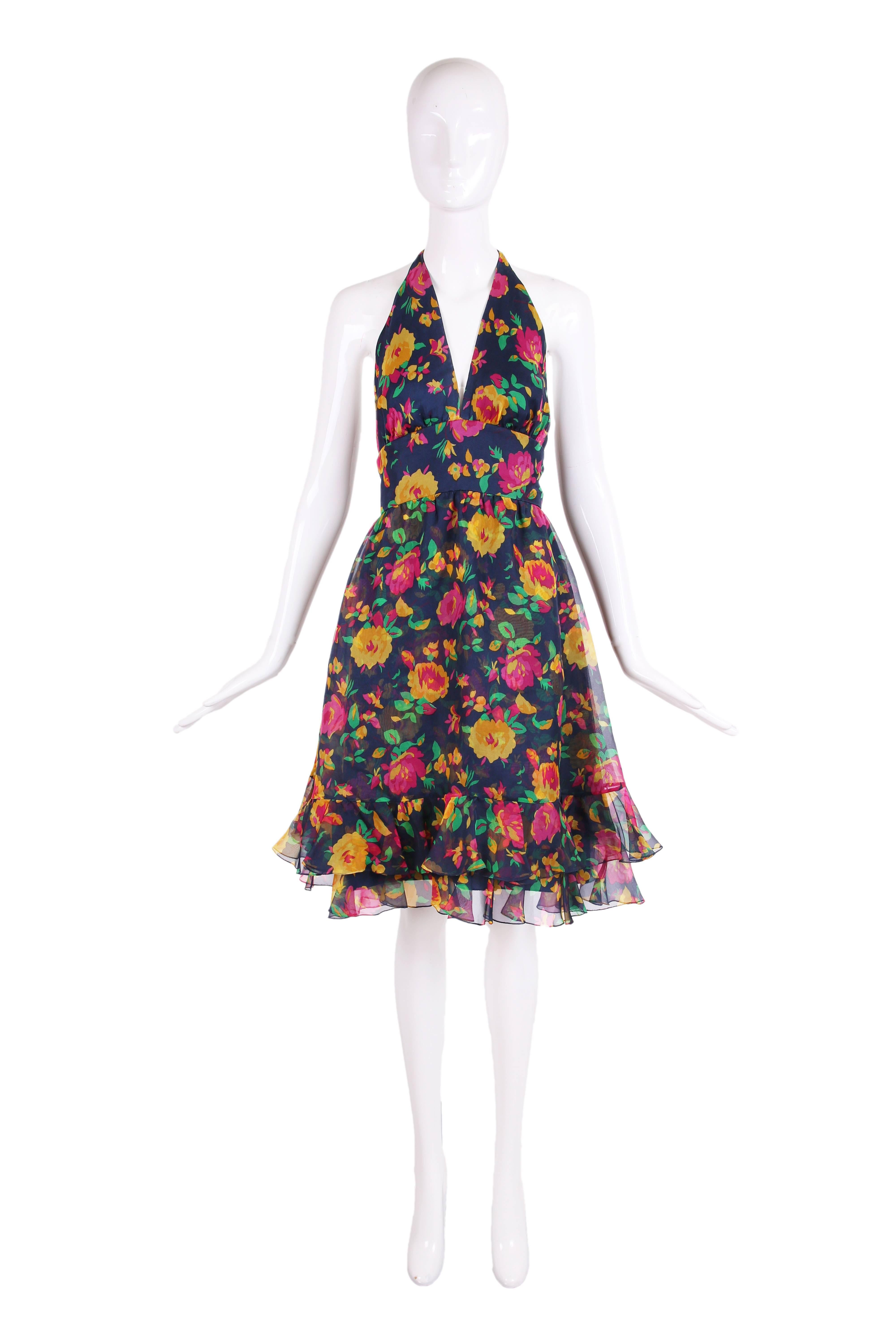 1970's Oscar de la Renta purple/pink, mustard and green floral printed multi-layered organza halter dress on a background of dark blue and ruffled hem. Lined at the interior, ties at back neck, hidden zipper at center back. Dress is in very good
