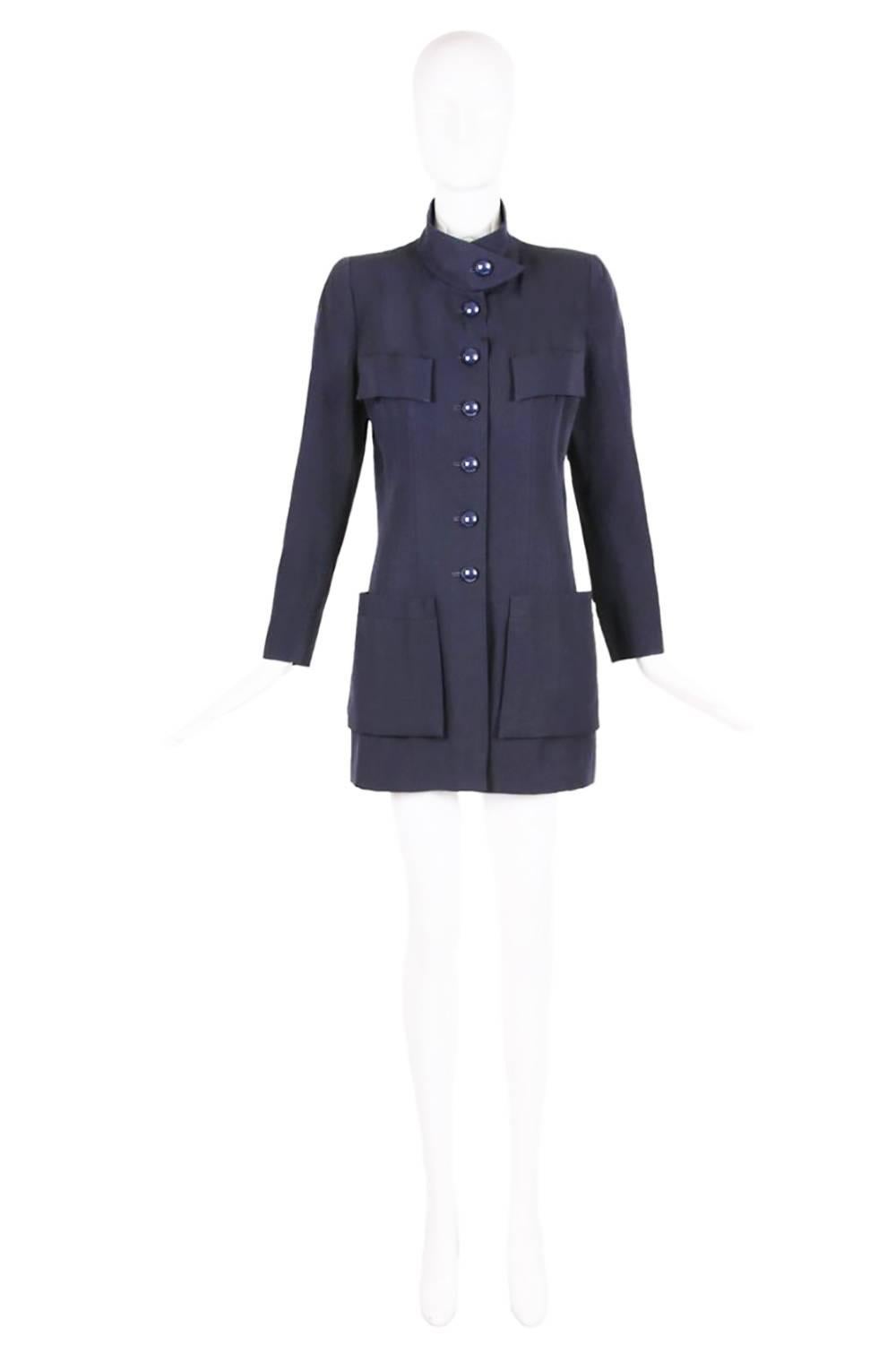 Chanel haute couture navy blue wool jacket with six oversized shiny button closures down center front and at the cuffs, two oversized frontal pockets at the hips, faux patch pockets at the chest and paneling design down the front and back. The