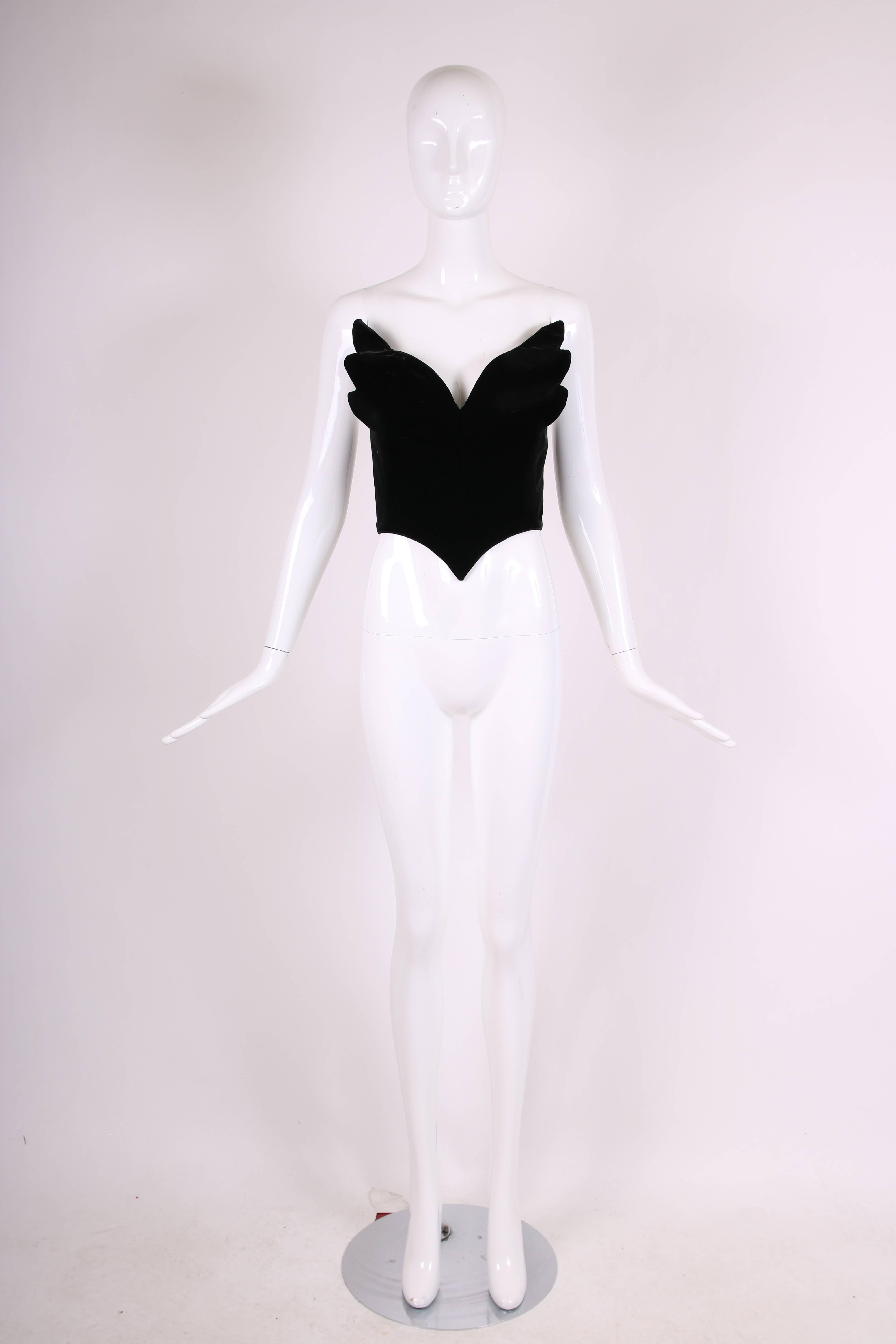 A ca. 1992 Thierry Mugler black velvet concept bustier in the shape of angel wings. Constructed from bendable wire sewn into the fabric interior, the angel wings give the impression of flying off the sides of the bustier. The corset itself is lined