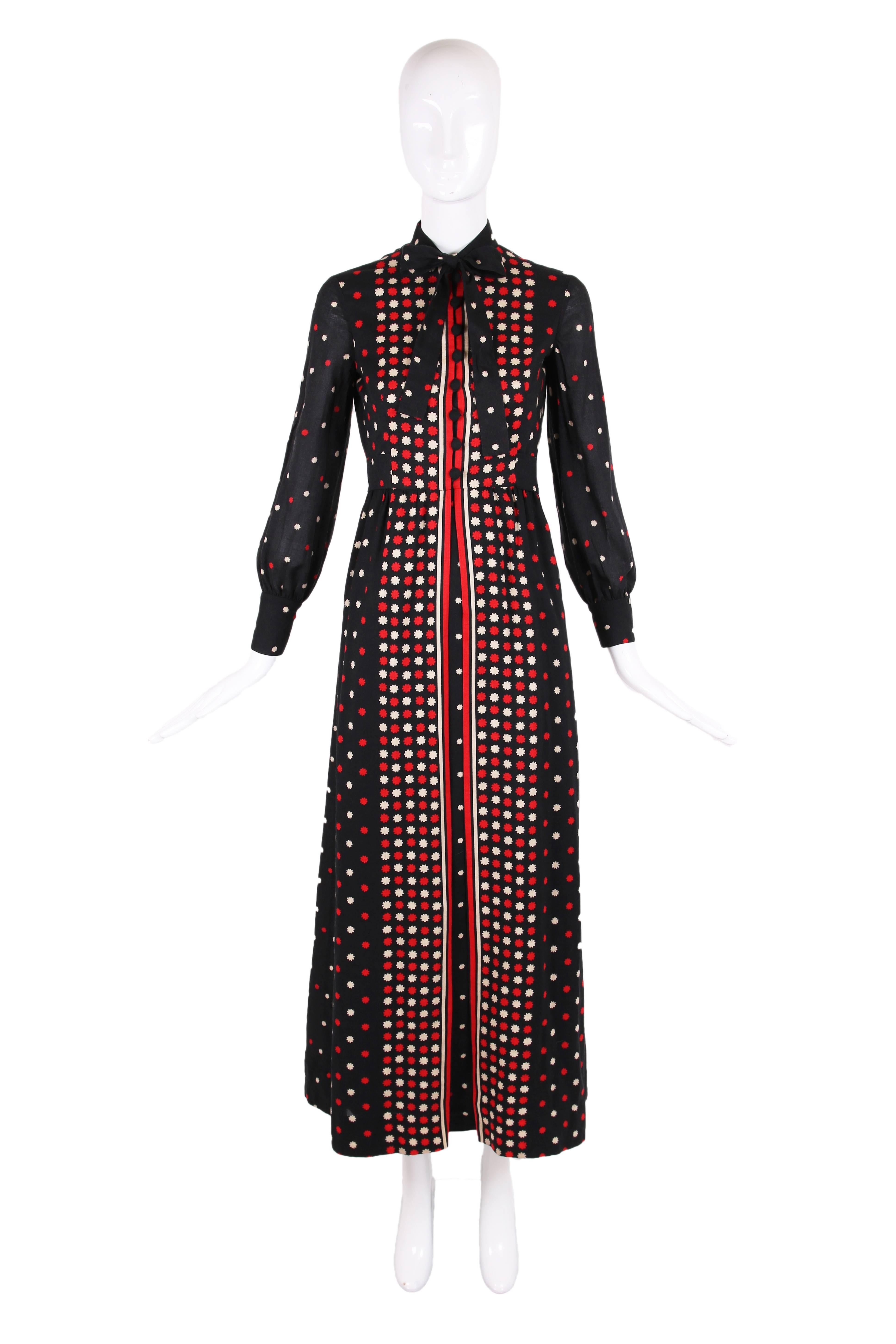 1970's Geoffrey Been black lightweight wool maxi dress with red and white abstract floral print. Features neckties, buttons down the bodice front and sleeves, an opening down the skirt front with a panel behind it and a slender A-line silhouette. In