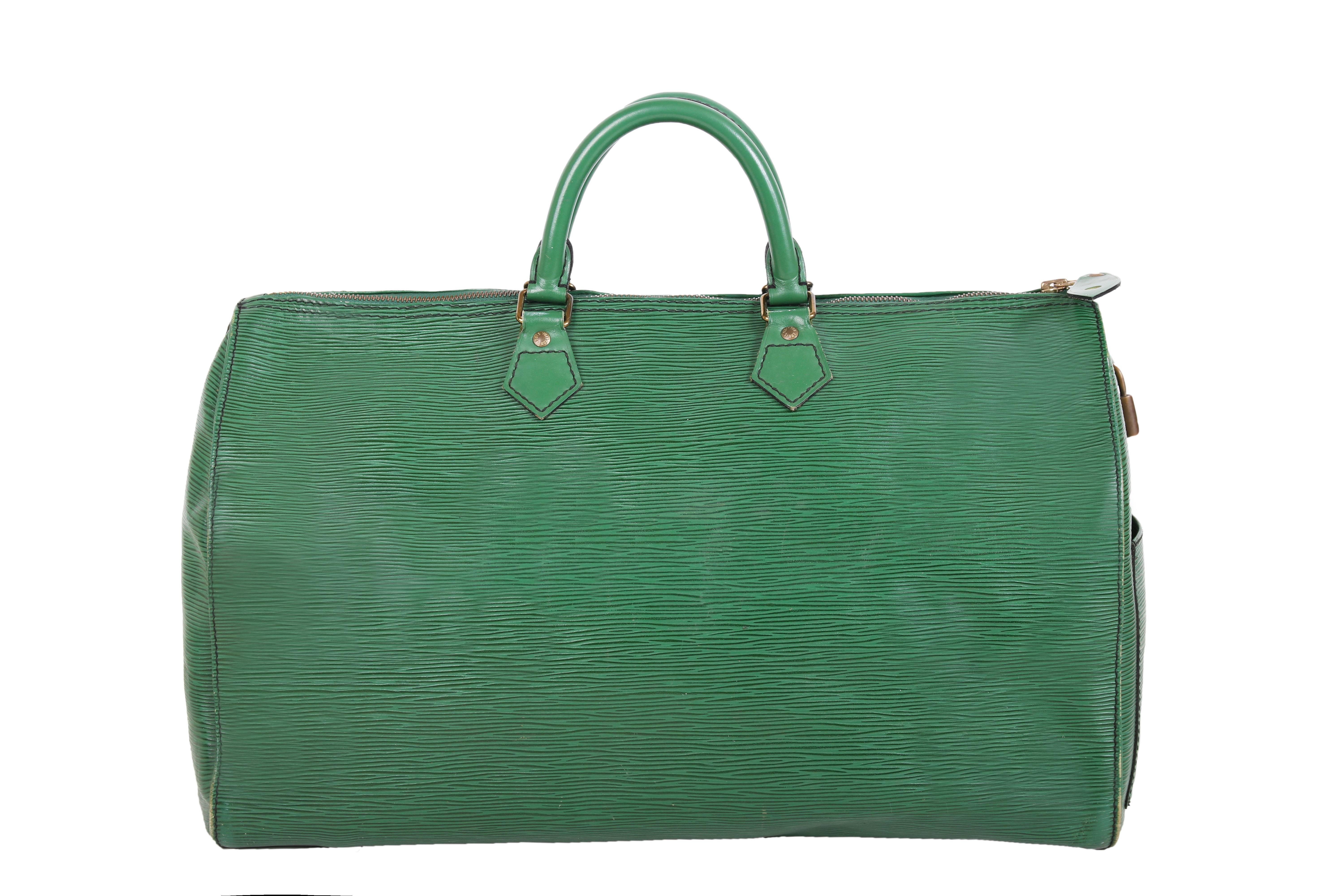  1990 Louis Vuitton green epi leather speedy bag with two top handles. The bag features one interior pocket, one exterior side pocket, and LV logo lock. LV logo is stamped onto buttons at each handle, zipper, and exterior leather tab near zipper. In