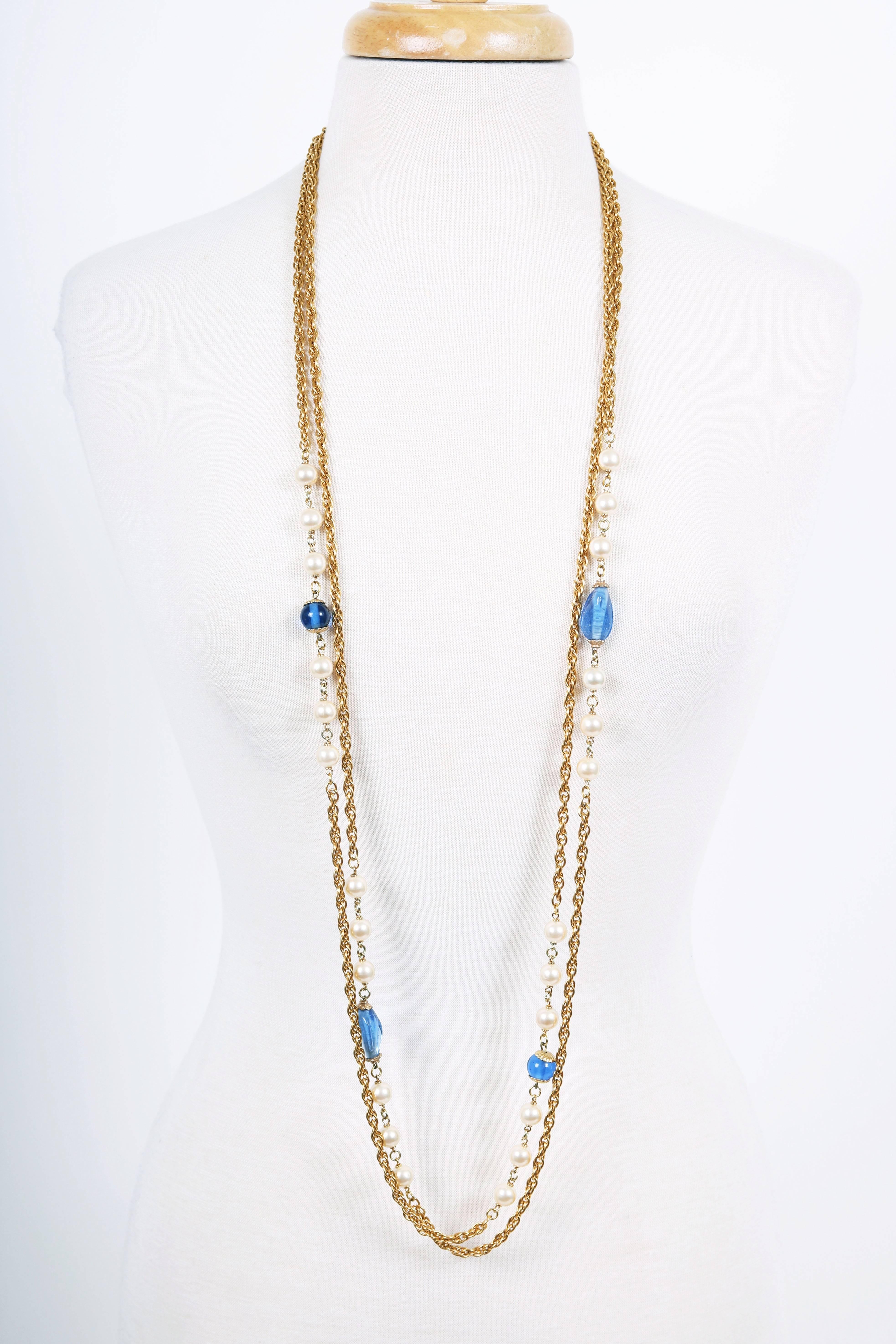 Sautoir Chanel à double brin en chaîne dorée du début au milieu des années 1980, entrelacé d'un motif alternant gripoix bleu (en deux formes) et perles rondes. Le collier se ferme à l'aide d'un anneau à ressort et d'un fermoir pivotant. Une