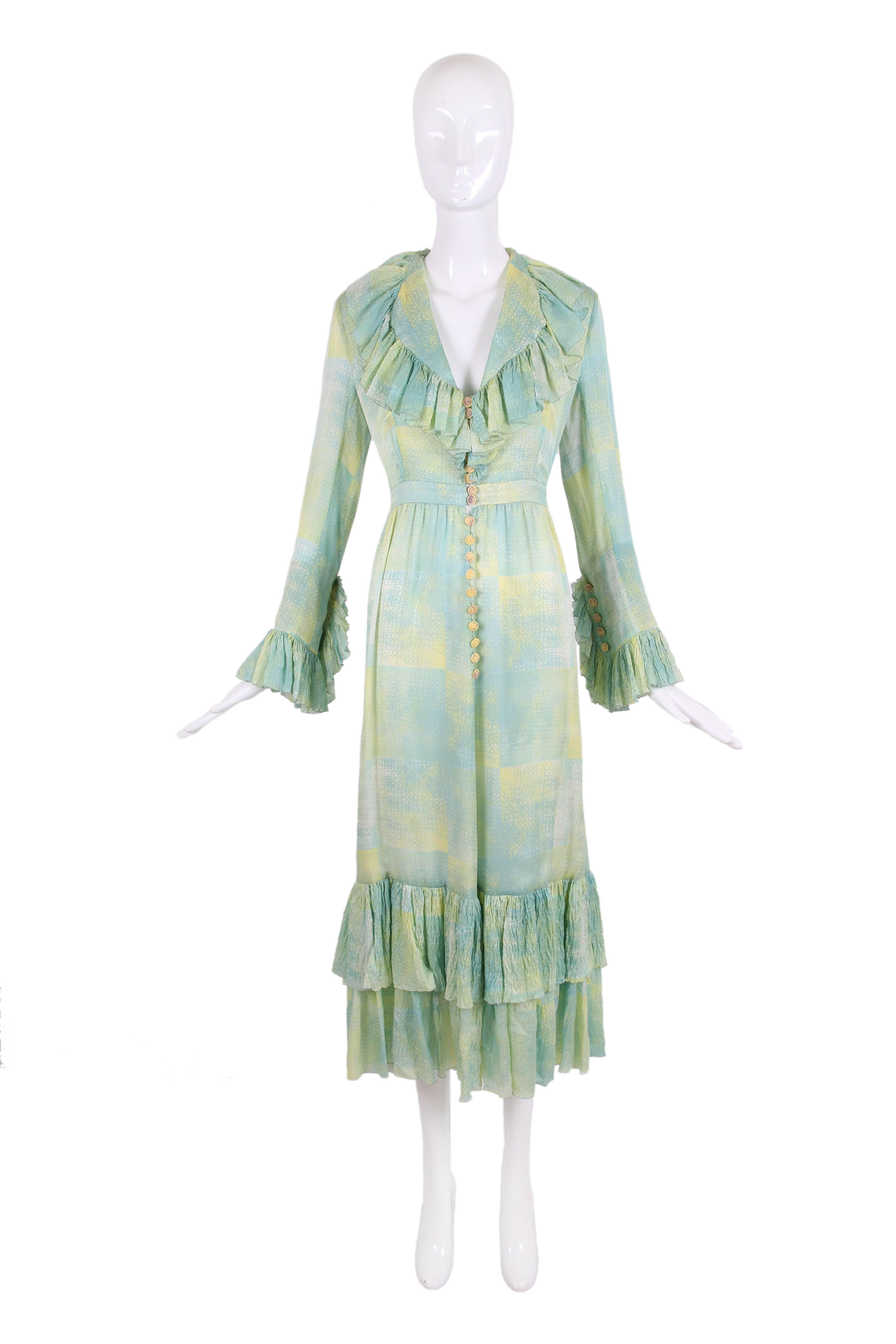1970's Chloe silk abstract print dress in shades of pale green, blue and yellow, with a deep v-neckline and ruffle trim at collar, sleeve cuffs and tiered hem. Dress fastens up center front with yellow buttons and green fabric loopholes, with the
