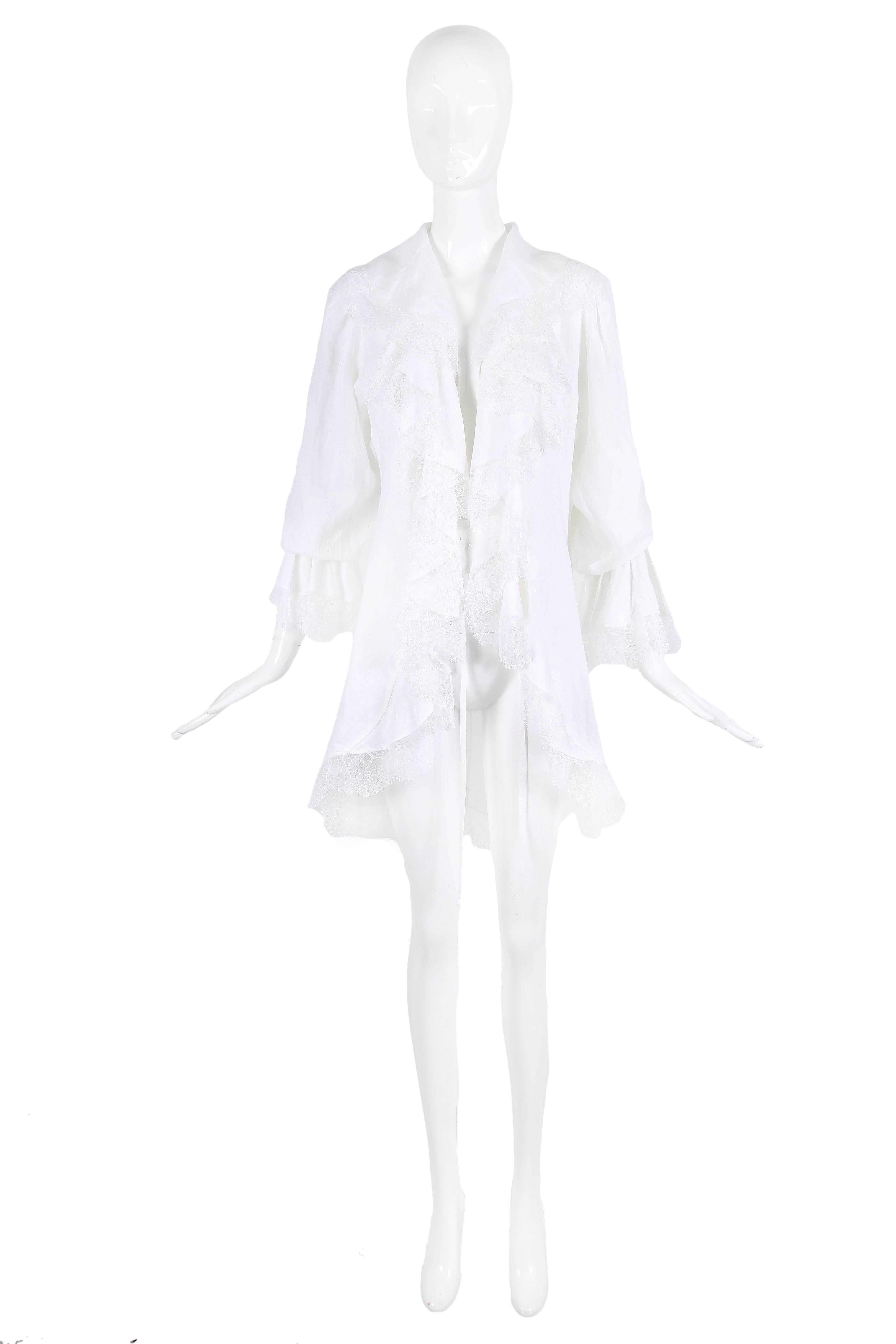 Vintage Yves Saint Laurent white poet blouse with exaggerated undulating ruffles at sides of center front opening which fastens via two extra long tie closures. Blouse features white lace trim at center ruffle design, sleeve cuffs, hem and collar.