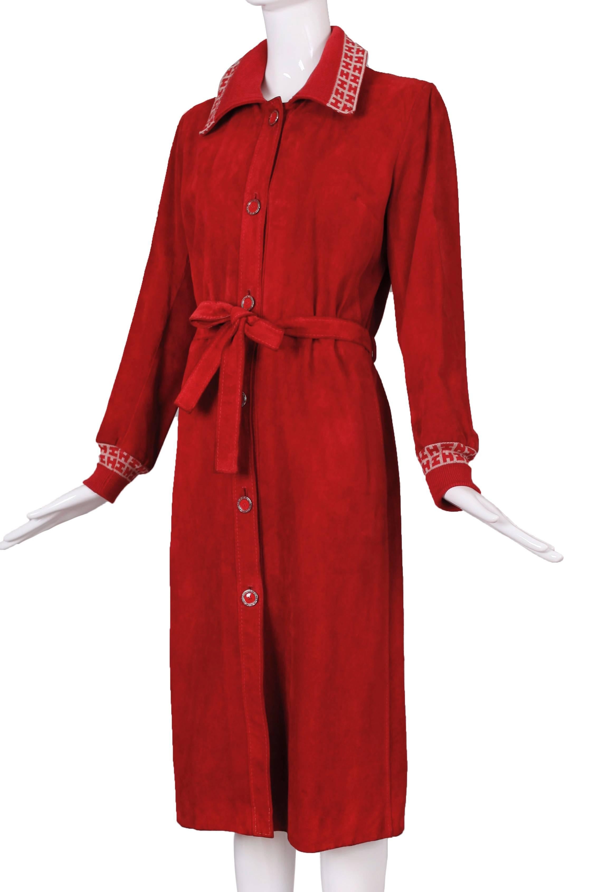 Hermes Sport red suede belted coat. Both collar and the cuffs are made from a wool blend and a repeating pattern of monogrammed “H’s.” The coat is in very good condition with some darkening at a few areas on the edge of the belt and some flaking on