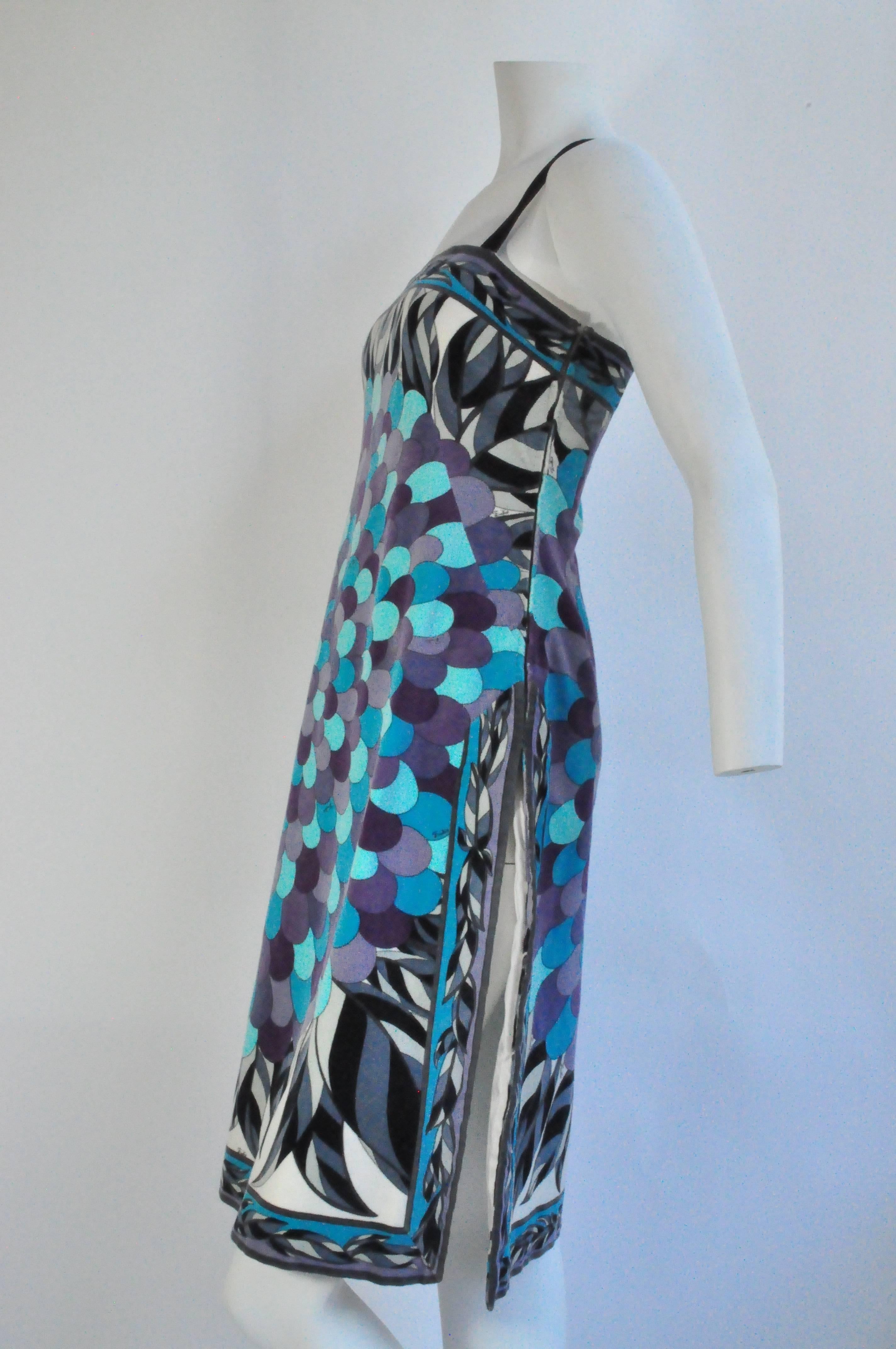 A vintage velvet Emilio Pucci day dress with spaghetti straps and a dramatic side slit up the left leg. Features a fantastical floral and leaf print in a color palette of greenish blues, purples, gray, sage green, white and black. Entirely lined at