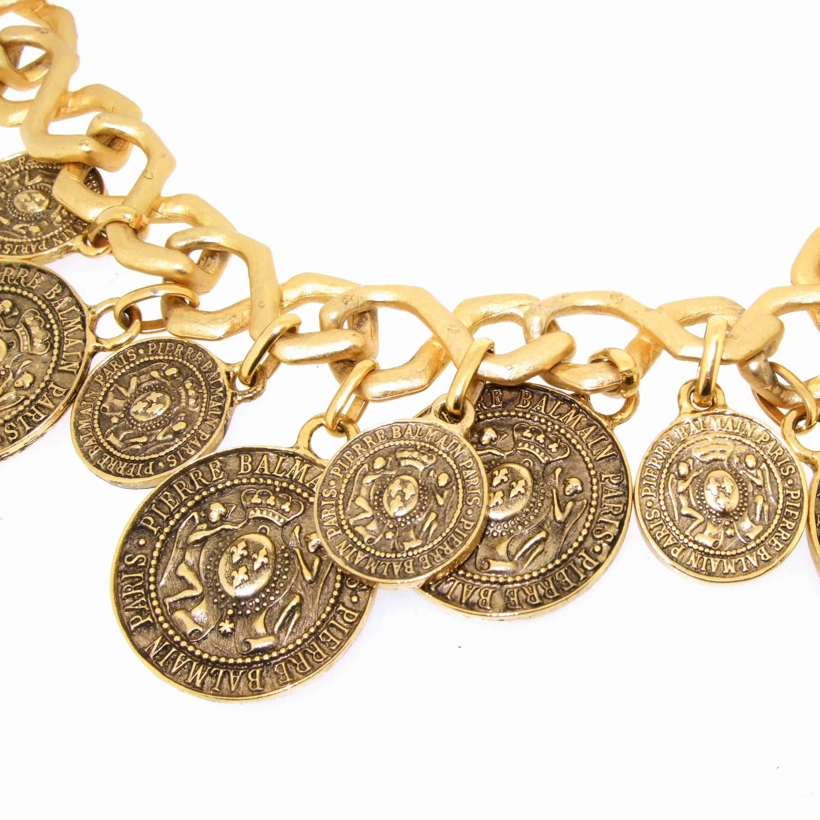 A vintage necklace by Pierre Balmain featuring antique effect coins charms. 

17 inches in length around the neck, Coin drop at the front 1.75 inches. 