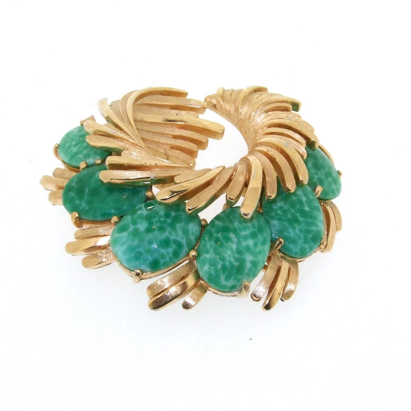A vintage brooch by Trifari, USA dating from the 1970s set with beautiful green glass that emulates Jade. 