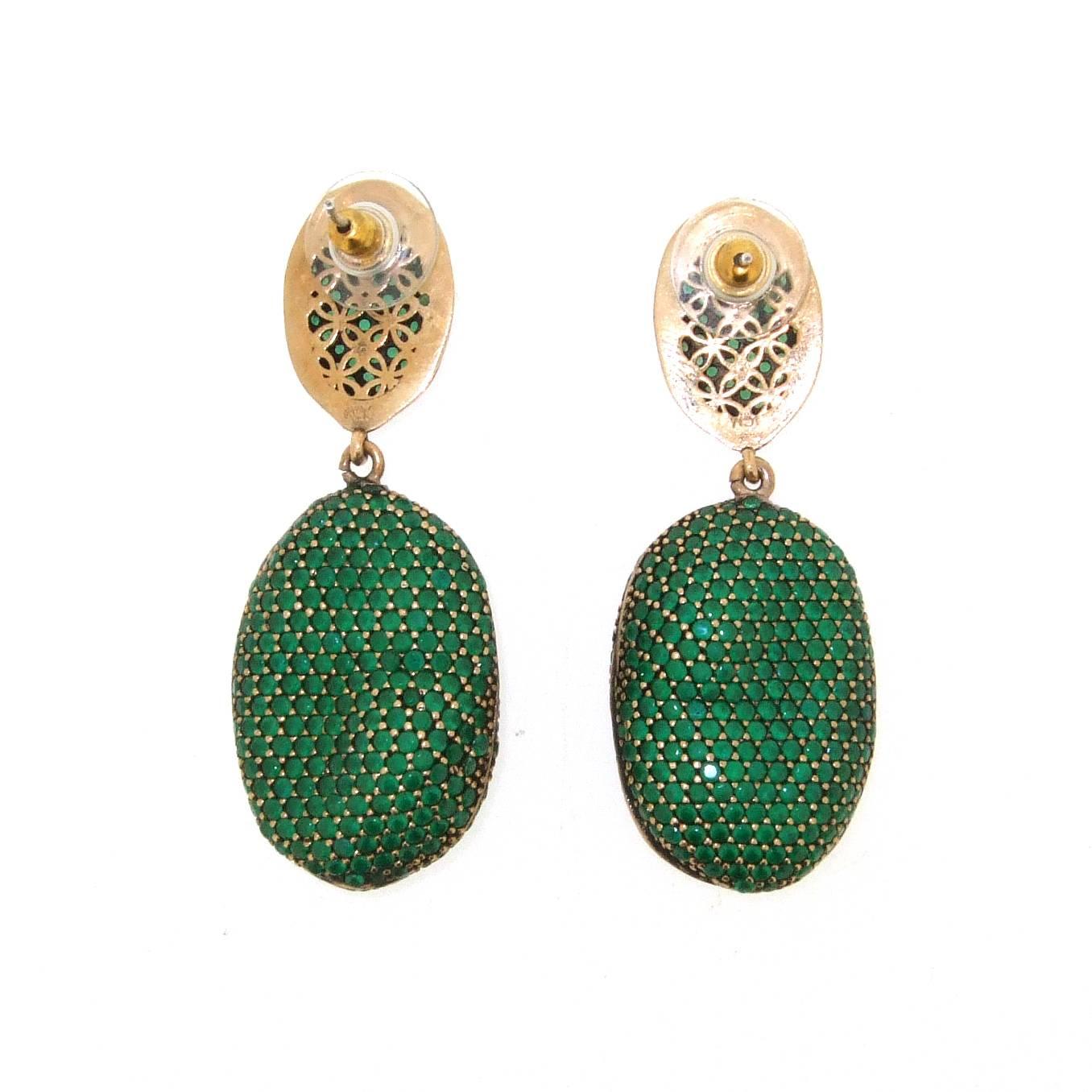 A stunning pair of pierced earrings by JCM London. Each misty emerald effect cubic zirconia encrusted pebble has a natural undulating uneven formation to give it the feel of the shape of a natural pebble. 

The smaller ovals measure 2cm long by