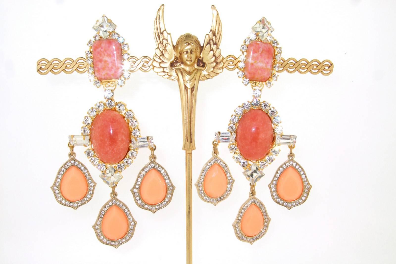 A beautiful pair of clip on statement earrings by Larry Vrba in gold toned costume metal set with pink agate stones and peach coral glass, with clear crystals edging. 

They measure 11.5 cm drop by 5.8 cm at the widest point, 2cm wide at the top.