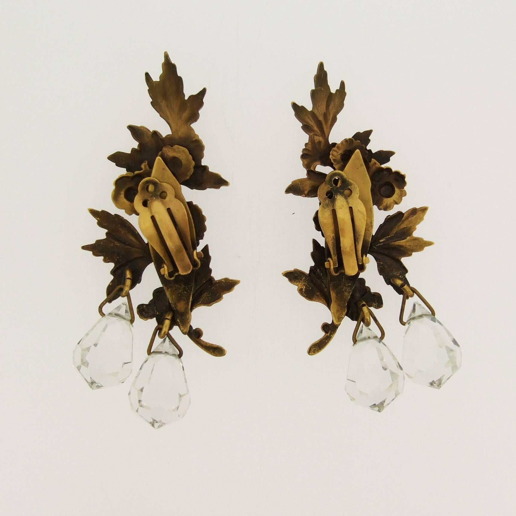 A rare pair of beautiful pair of clip on earrings by Joseff of Hollywood. Featuring a floral spray in bronzed costume metal with a duet of crystal drops. 

They measure 7.3 cm drop by 3.2cm at the widest point, the crystals are 1.2cm deep.