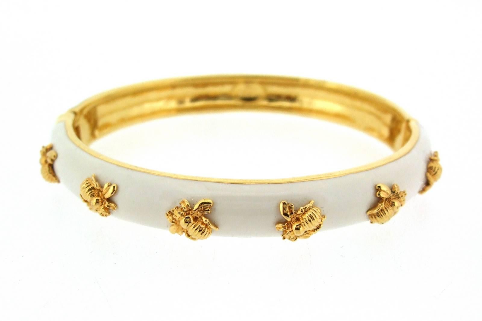 A beautiful gold plated white enamel bracelet by Joan Rivers featuring golden bees all the way around the bracelet. This is a clamper bracelet with a hinge. 

Signed on the back Joan Rivers. 

It measures 7 1/2 inches around the wrist, 0.9cm