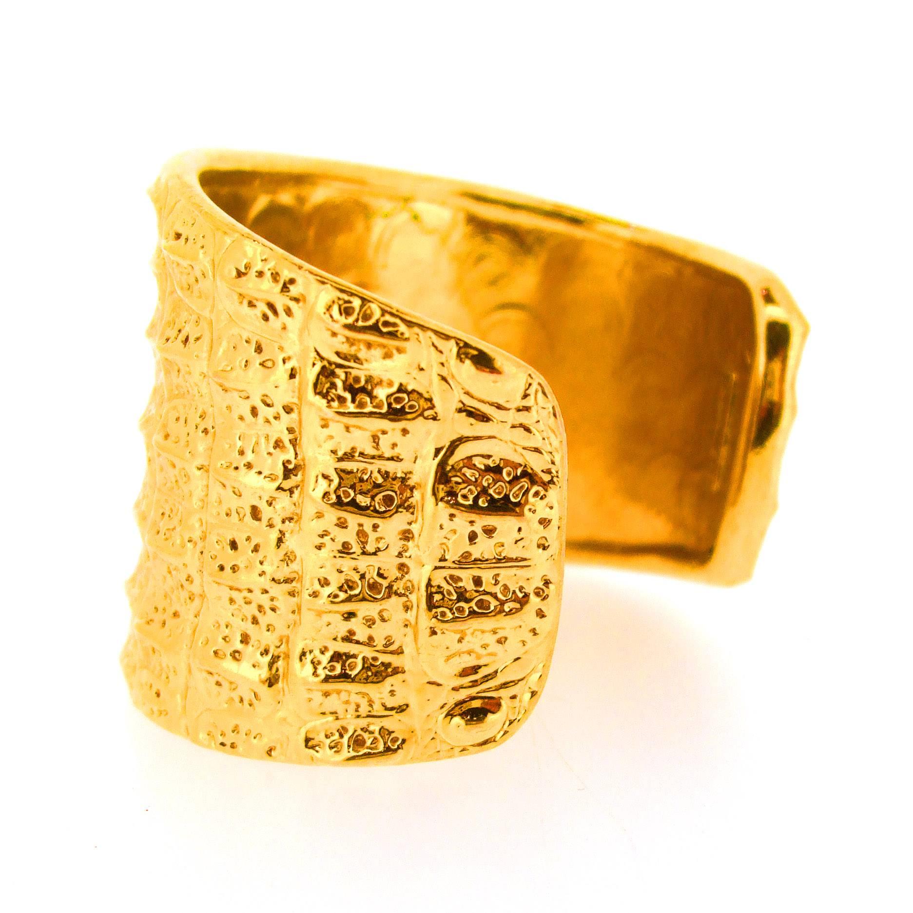 A fabulous cuff bracelet by Yves Saint Laurent. Gold plated costume metal emulating crocodile skin effect 

It measures 6.5cm across, 4.6cm high/ deep, 7 inches/ 17.5cm around the wrist. 