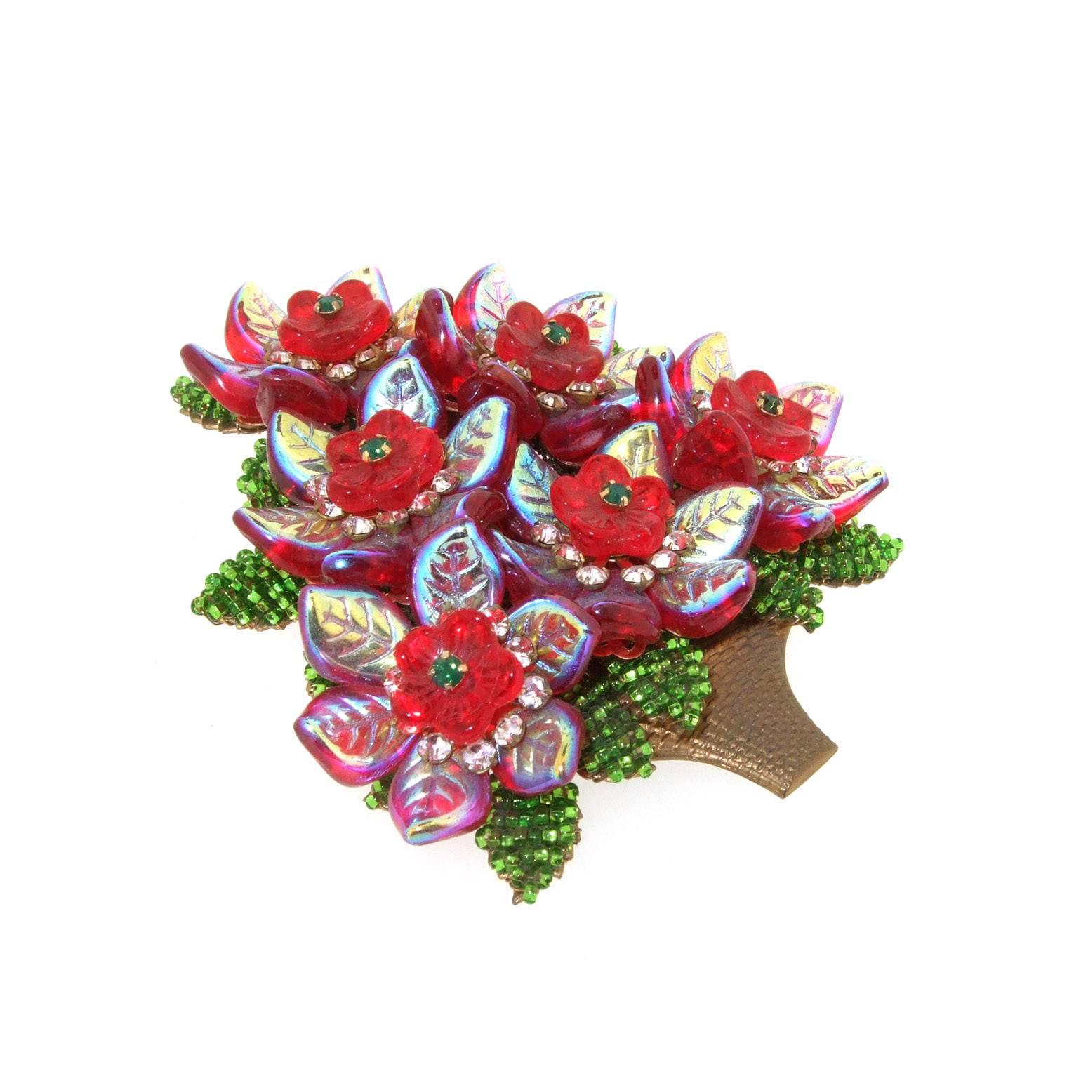 A large floral Christmas Tree brooch by Stanley Hagler, NYC. In gold brass metal hand beaded with vintage glass leaves and flowers.

It measures 8.4cm wide by 8.3 cm high.