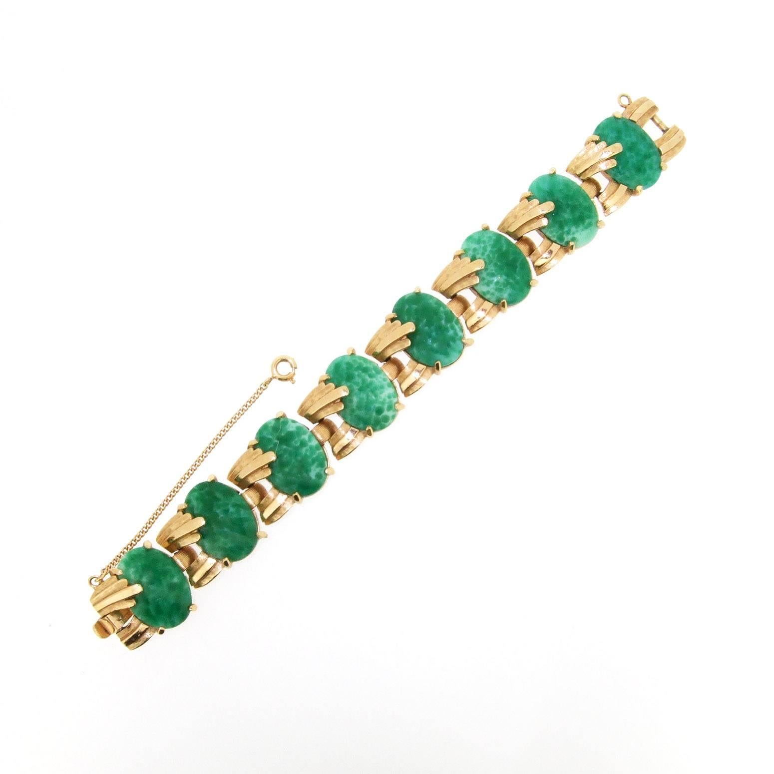 A beautiful vintage bracelet by Trifari USA from the 1960s in gold plated metal set with pretty green glass emulating jade. 

It measures 6 3/4 in length/ 16.5cm, by 1.8cm wide, by 0.6cm deep.


