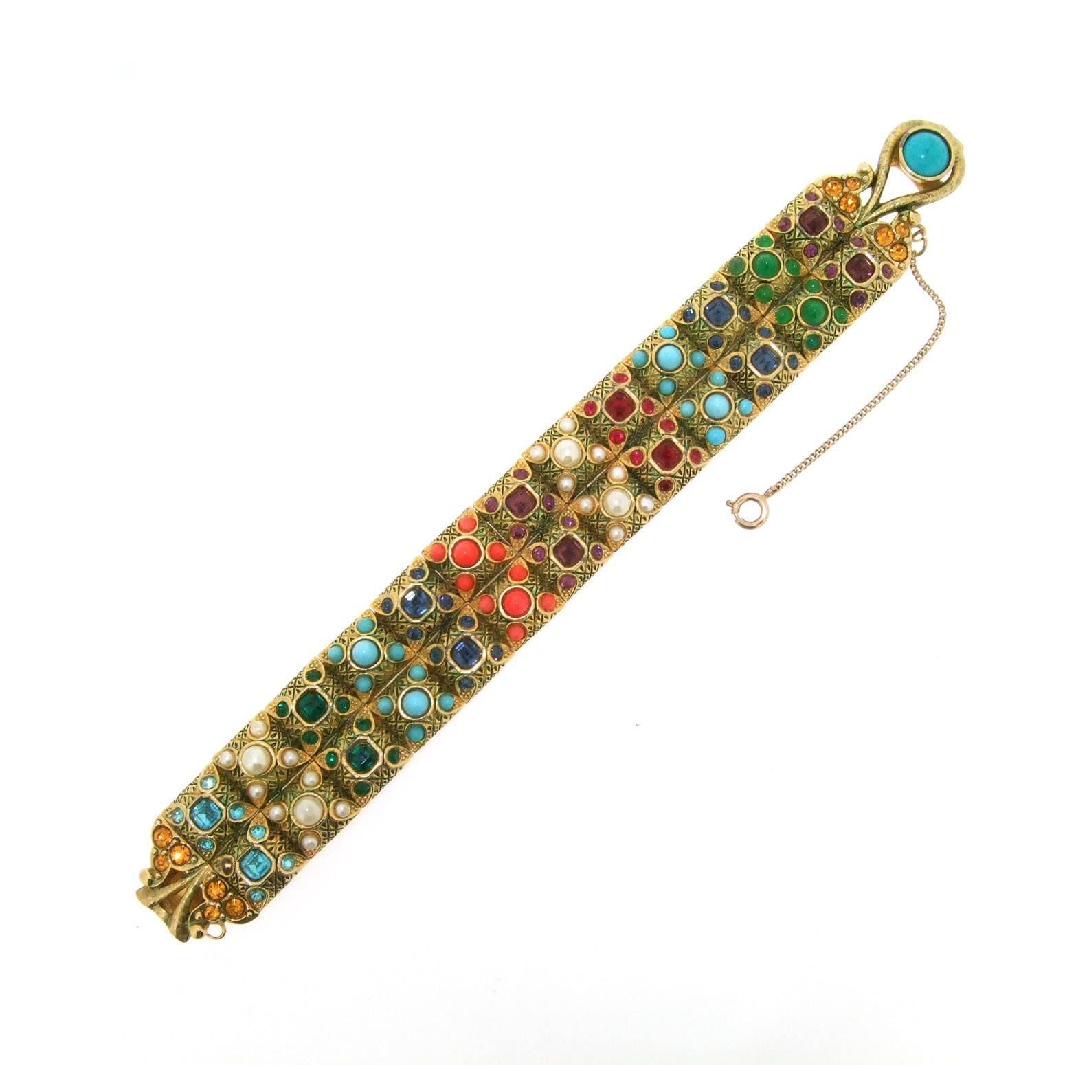 A beautiful vintage bracelet from the 1960s by Boucher, in gold tone costume metal set with rainbow coloured glass and crystals. 

It measures 7 inches/ 18cm around the wrist, 2.1cm wide, 0.9cm deep.

