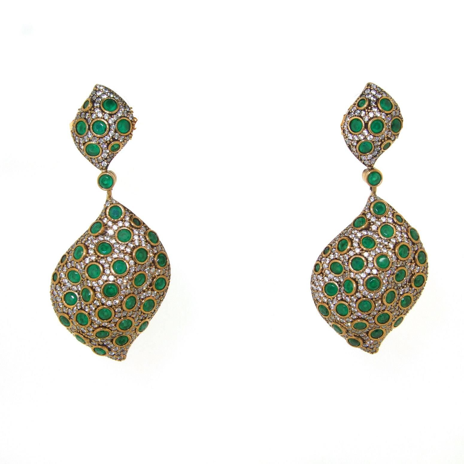 A beautiful pair of pierced earrings by JCM London set with green and clear crystals, emulating emeralds and diamonds. Set in gold plated costume metal.

They measure 7cm drop by 1.5cm wide at the top and 2.8cm wide at the lower section, 1.8cm deep.