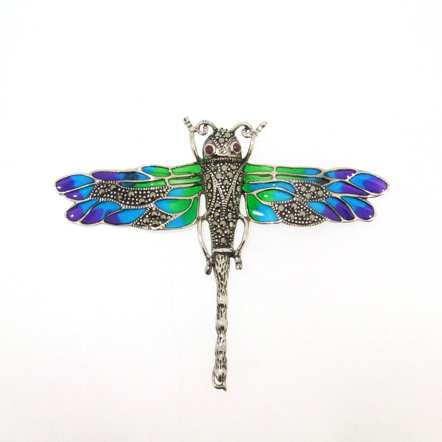 A beautiful Art Nouveau style dragonfly brooch set in sterling silver, hallmarked 925, with see through 'pic a jour' enamel and decorated with sparkling marcasites.

It measures 8cm across by 6.2cm high. 

Our shop Hirst Antiques is in London,