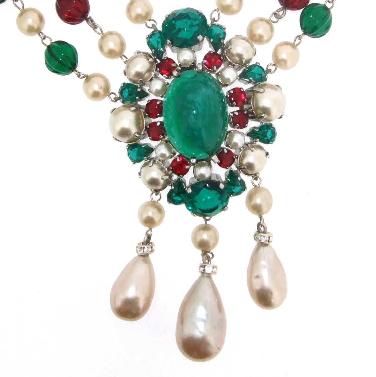 A Stunning classic Christian Dior Necklace dated 1960 featuring emerald and ruby coloured glass and glass pearls in a triple strand necklace with centre piece. The necklace length measures 18 - 20 inches. The centre piece measures 9.5cm drop by 5cm
