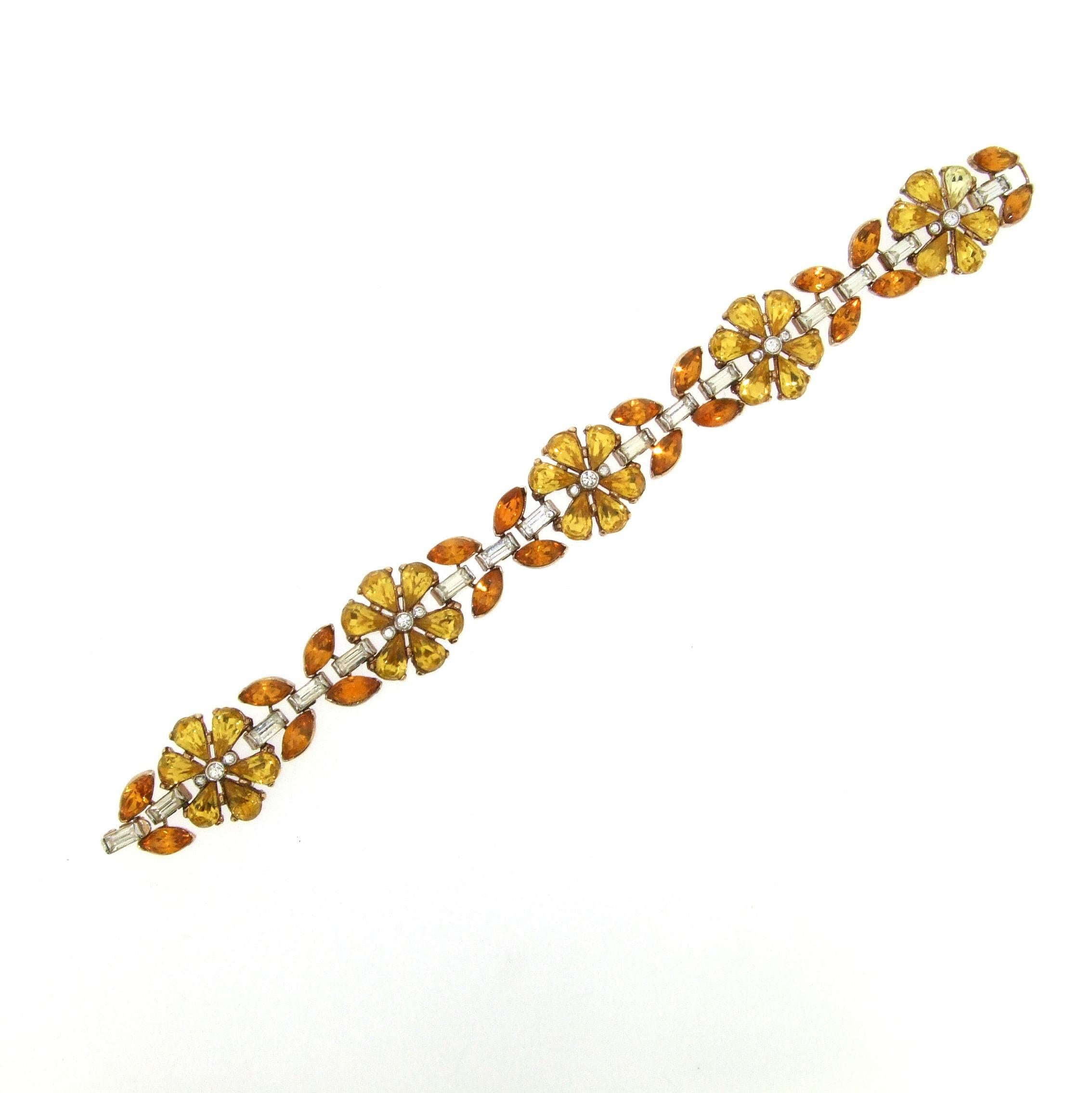 A beautiful floral two tone yellow citrine effect crystal bracelet by Trfari accentuated with clear baguette stones. 

Trifari was founded in the USA by Italian Gustavo Trifari in 1910. Chief designer of Trifari between 1930 and 1968 was Alfred
