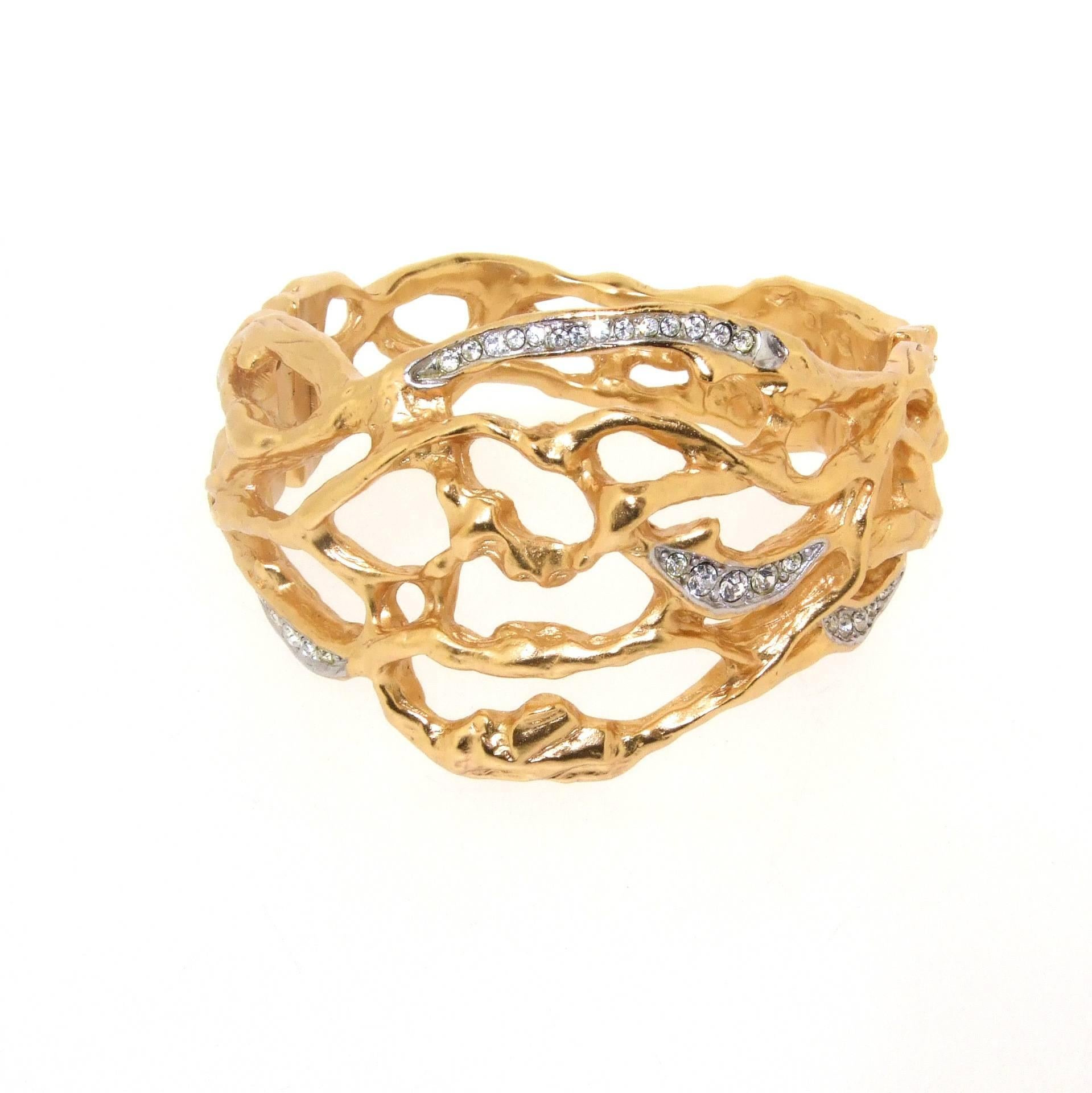 The 'Treasured Vine' clamper bracelet by Elizabeth Taylor for Avon. Crafted of openwork goldtone metal set with crystals. Symbolizing the intricate twinings of our lives and each sparkle representing a special moment.

Elizabeth Taylor designed