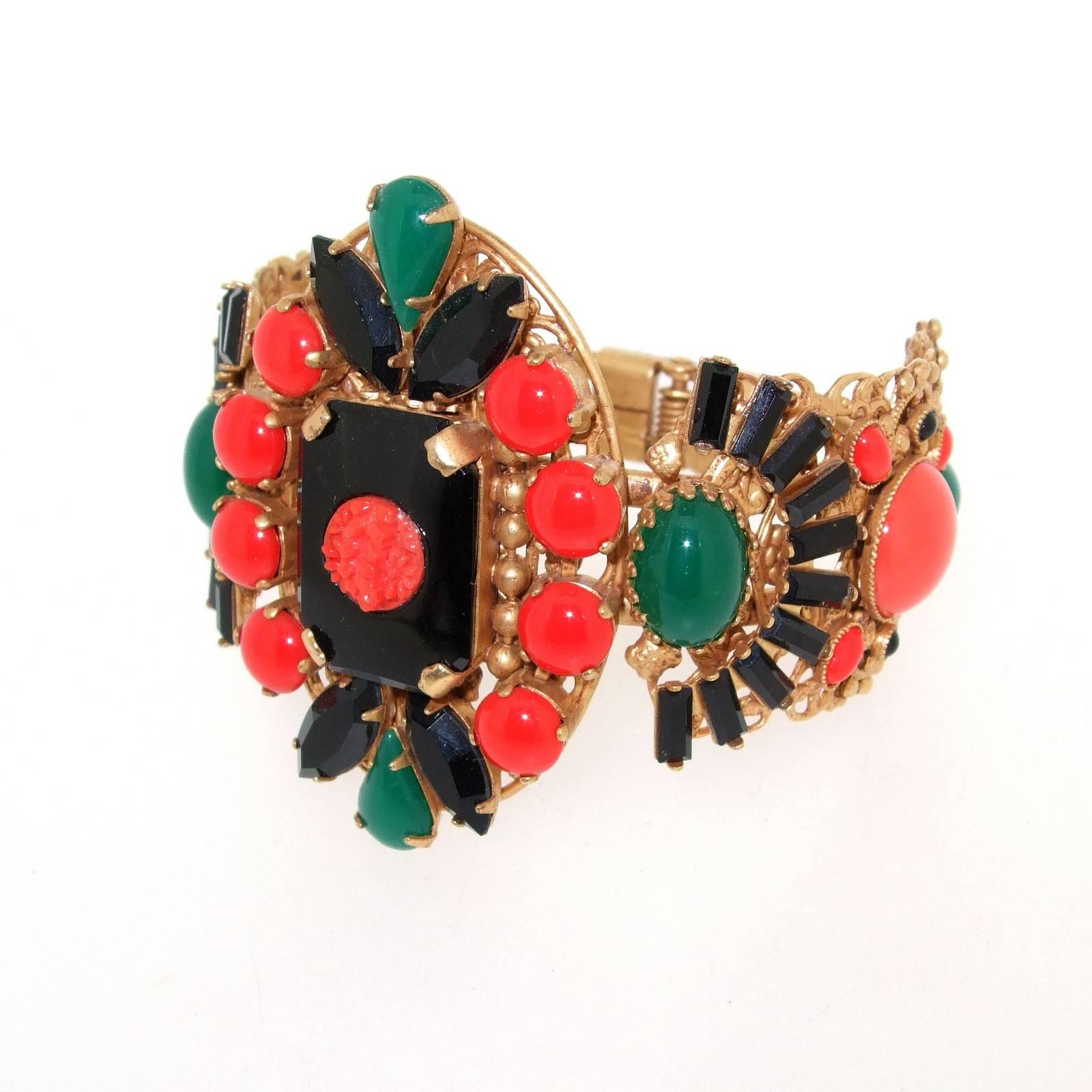An exquisite Art Deco style clamper bracelet by Askew London. Set with vintage glass, the centre piece emulating carved coral, with striking black, coral and jade effect glass, each setting  the other colour off. 

Each Askew piece is handmade by