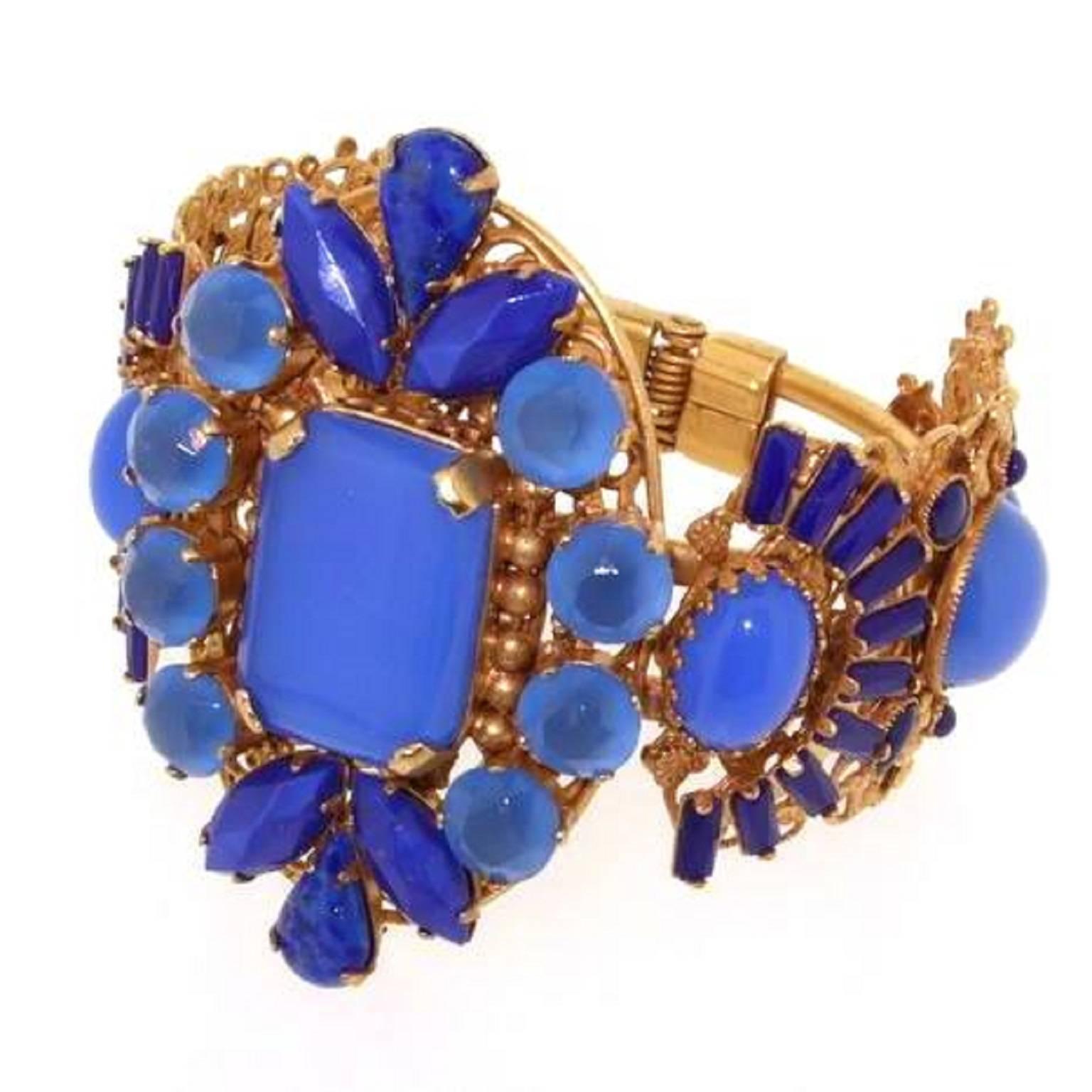 A stunning statement clamper bracelet by Askew London. Nickel free metal, gold plated and set with vintage glass and crystal in lapis, cobalt and corn flower blues. 