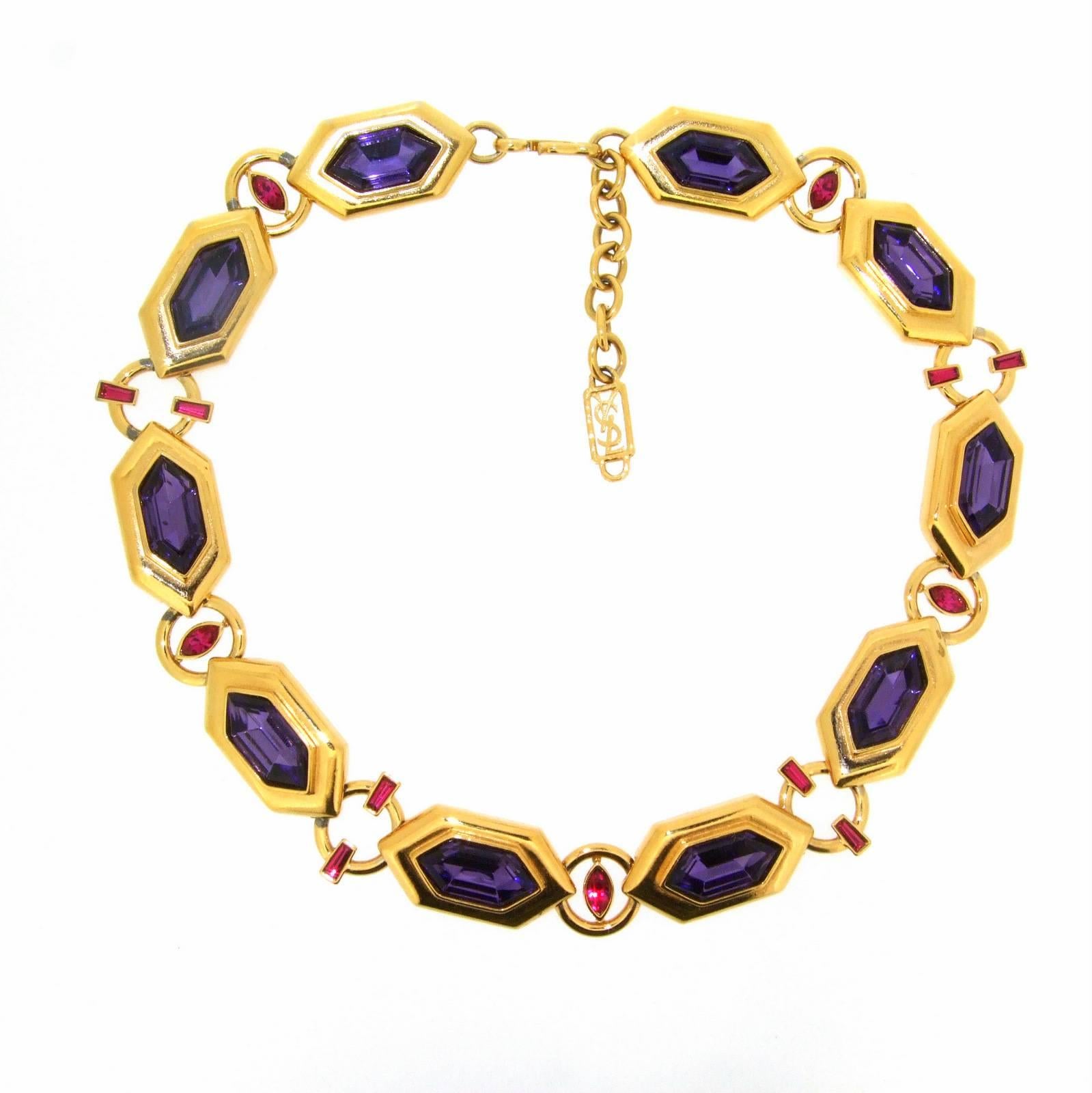 A fabulous Vintage Necklace by Yves Saint Laurent (YSL). Purple and ruby red crystal glass faceted stones set on a gold plated costume metal. It measures 18-20 inches in length, each section with a purple stone is 3.5cm long and 2cm wide.
