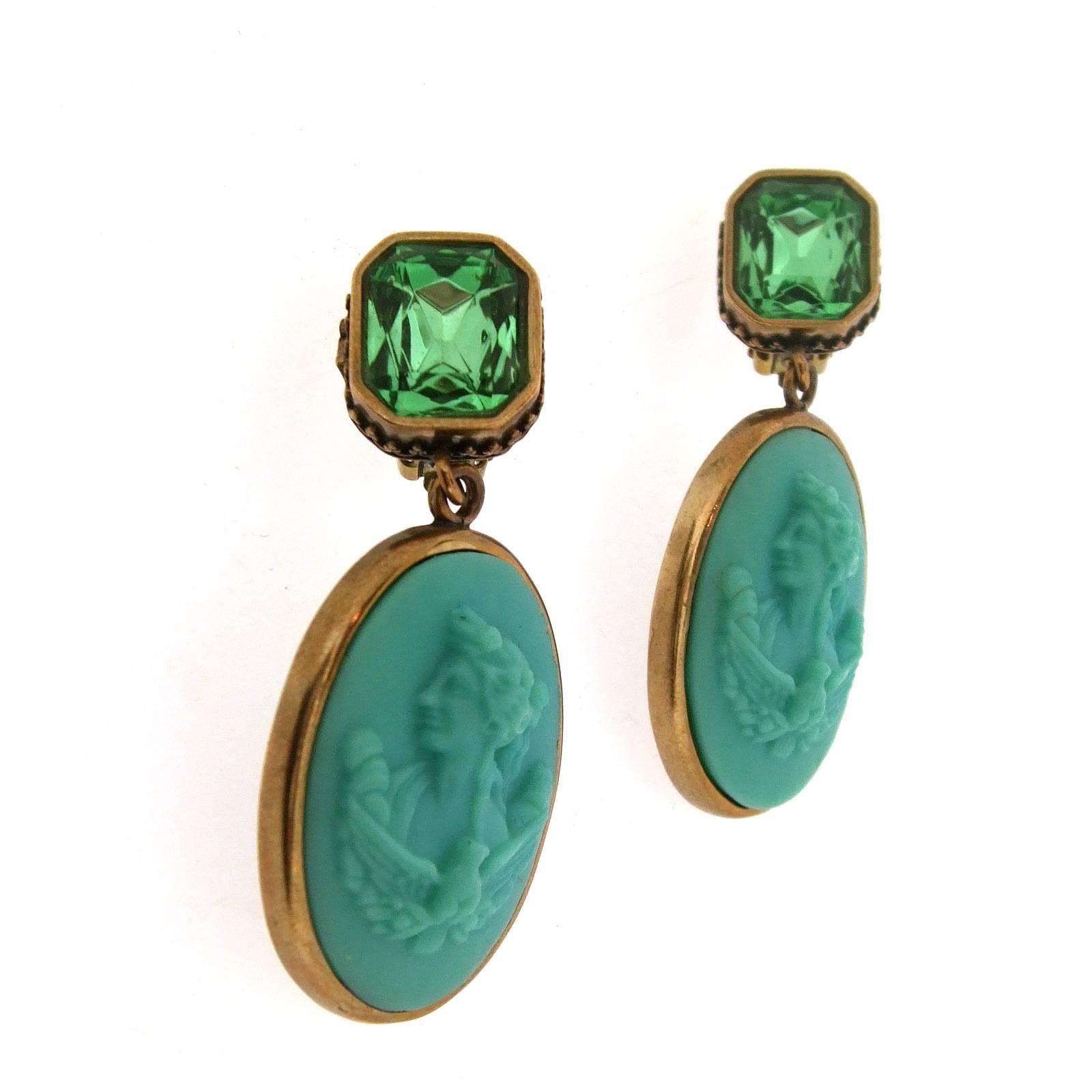 A pair of two part clip on earrings, with a turquoise German glass cameo. Top is green faceted glass. Cameo image is reproduced from Greco/Roman mythology.

They measure: 5.1cm drop by 1.1cm wide at the top and 2.3cm wide at the bottom. 