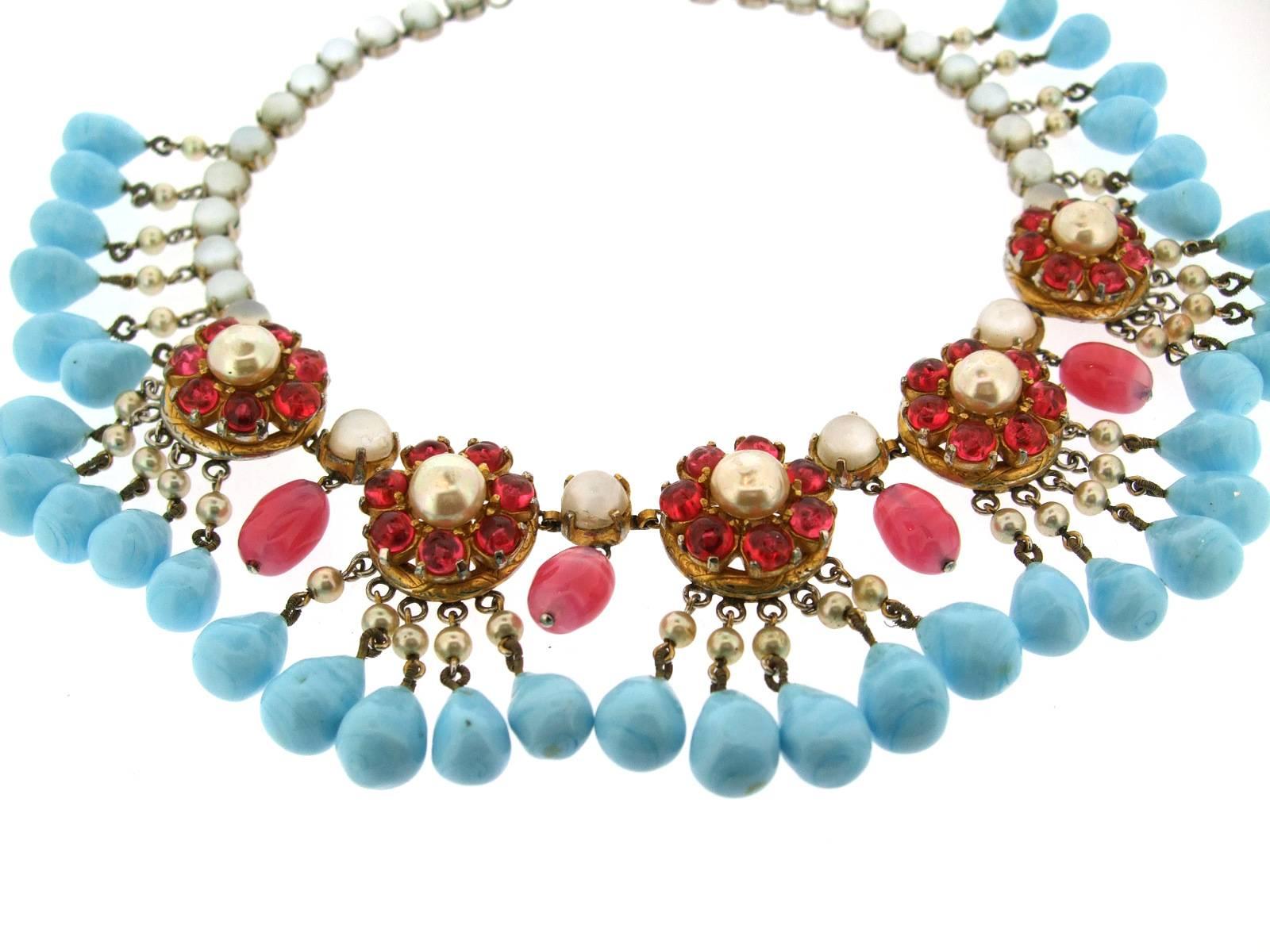 A rare collectors piece necklace by Mitchel Maer for Christian Dior from 1950. A turquoise glass fringe decorating florettes of glass rubies and glass pearls with a chain of moonstone effect stones. Silver toned costume metal.

Centre drop is 1