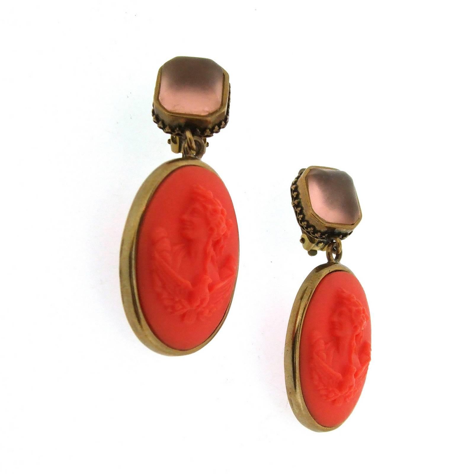 A pair of two part clip on earrings, with a coral German glass cameo. Top is pale pink opaque glass. Cameo image is reproduced from Greco/Roman mythology.

They measure: 5.1cm drop by 1.1cm wide at the top and 2.3cm wide at the bottom. 