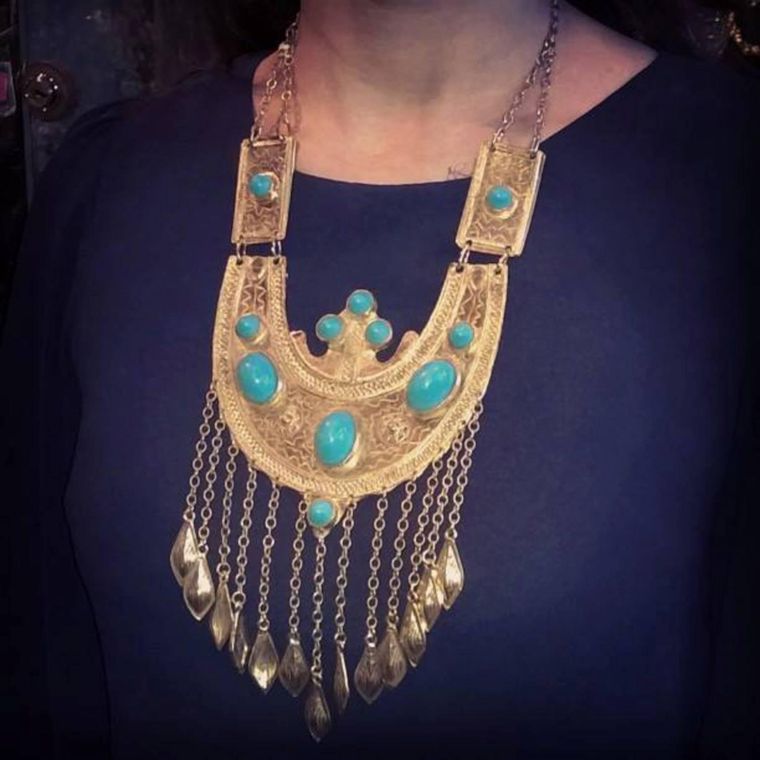 An amazing vintage statement Etruscan style necklace by Alexis Kirk, gold plated and featuring turquoise glass cabochons, with a fringe of metal beaded chain.

This piece reflects how Alexis Kirk was inspired by symbolism of different cultures and