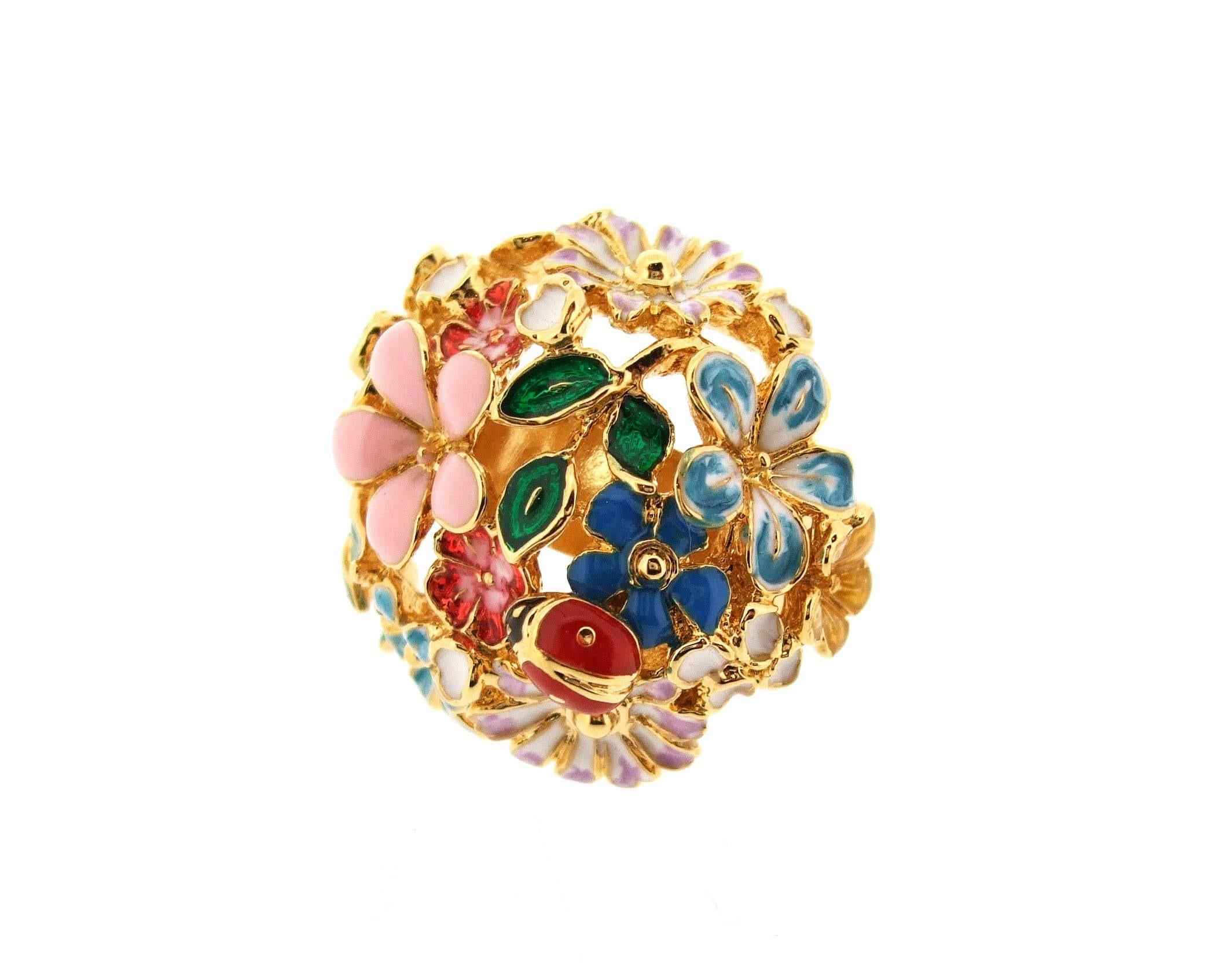 A beautiful statement ring decorated with enamel multicoloured flowers and a ladybird by Bill Skinner. Made form 18k gold plated costume metal.

It measures 2.9cm across the width by 2.6cm, it stands 2.8cm high from the base of the ring to the