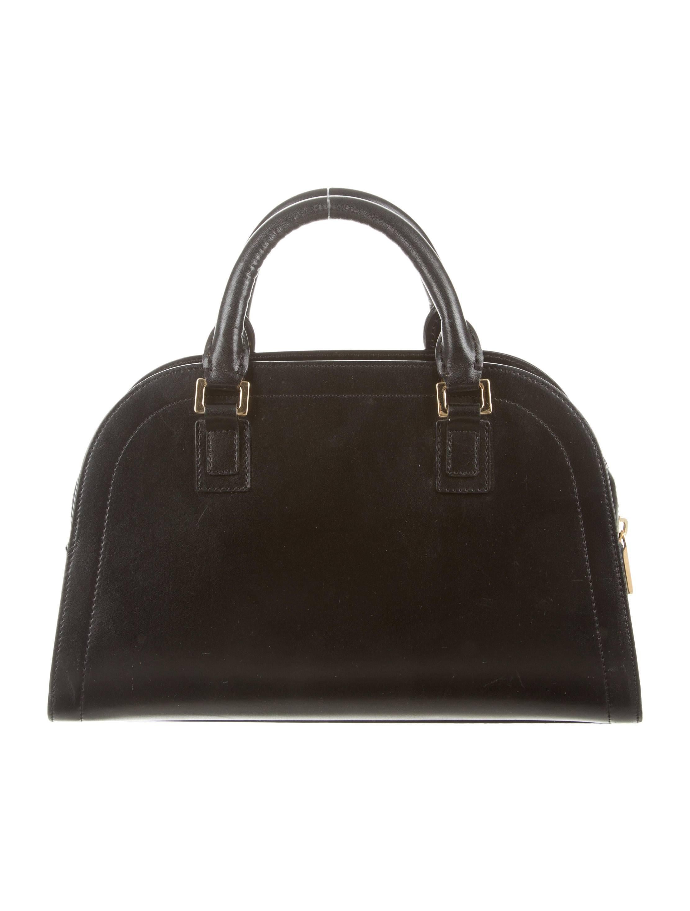 CURATOR'S NOTES

Black leather 
Gold tone hardware
Woven lining
Zip closure 
Handle 3.5”
Measures 11