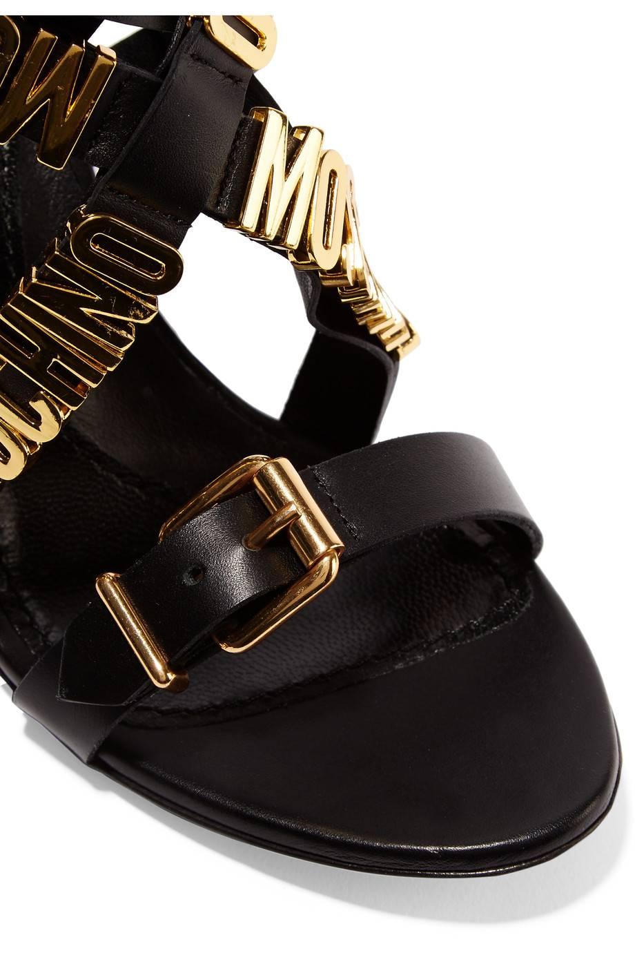 NOTE DEL CURATORE

Lascia che siano i tuoi piedi a parlare con questi sandali Moschino NUOVI e SOLD OUT in pelle nera con finiture dorate 