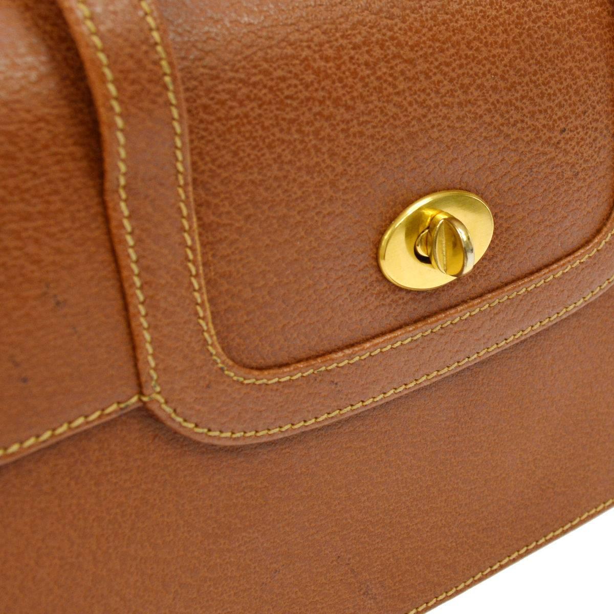 CURATOR'S NOTES

Gucci Vintage Cognac Leather Top Handle Kelly Style Satchel Crossbody Bag  

Leather
Gold tone hardware
Turnlock closure
Leather lining
Made in Italy
Top handle 3"
Measures 9.5" W x 6.25" H x 3" D 
Shoulder strap