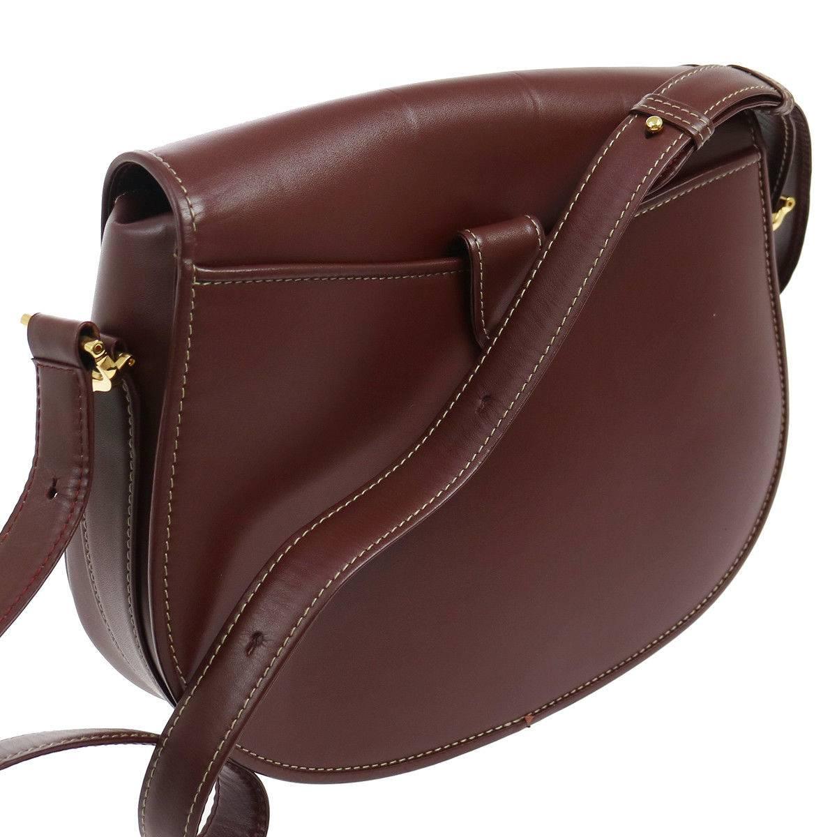 Cartier Bordeaux Leather Gold Saddle Evening Flap Shoulder Crossbody Bag W/Accessories 

Leather
Gold tone hardware
Satin lining
Date code present
Made in Italy
Adjustable shoulder strap 8.5-17" 
Measures 11" W x 9" H x 3" D