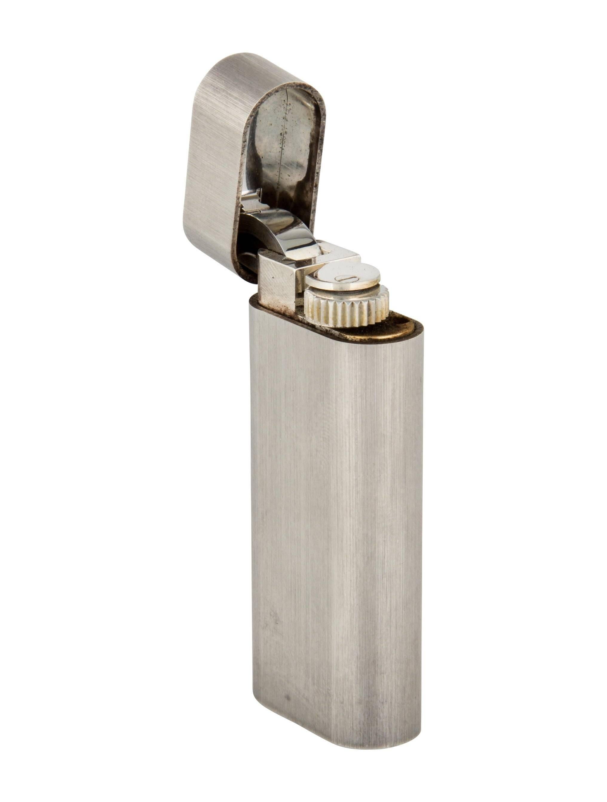 Cartier Textured Silver Metal Men's Cigar Cigarette Lighter in Box

Metal
Silver tone
Measures 1" W x 2.25" H x 0.50" D 
Includes original Cartier box