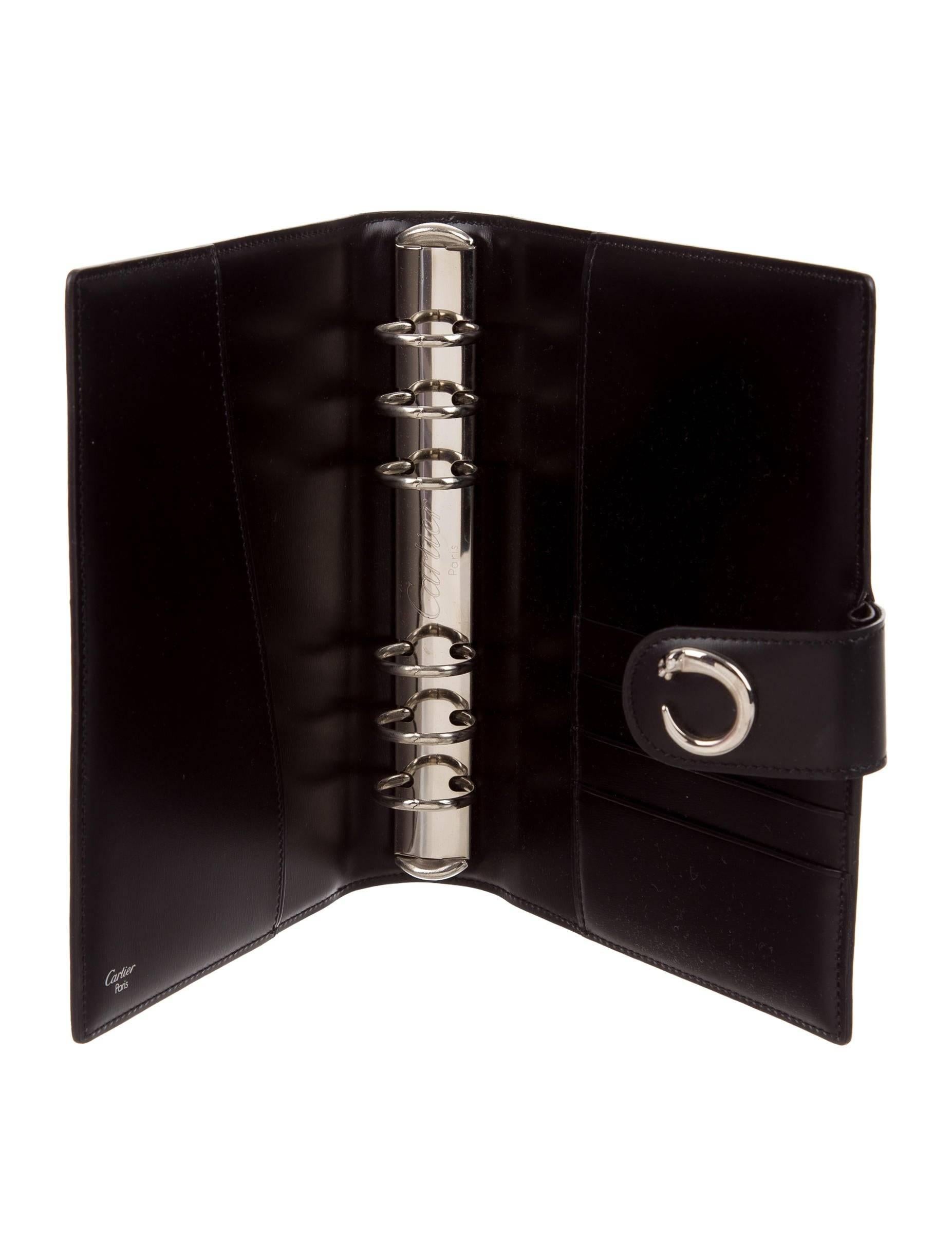 Cartier New Leather Silver Men's Women's Charm Logo Travel Agenda Planner Date Book in Box

Leather 
Silver tone hardware
Six ring binding
Snap closure
Measures 6.5" W x 7.5" L x 1.5" D 
Includes original Cartier box