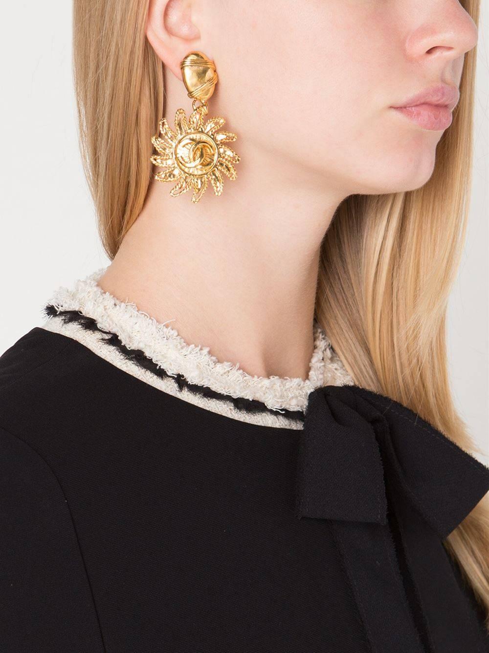 Give me the sun draped in CC's.  Ultra chic Chanel vintage gold plated sun motif dangle earrings.

Metal
Gold tone
Clip-on
Made in France
Measures  3" L x 1.7" W x 1.6" H
Includes complimentary pair of new earring backs