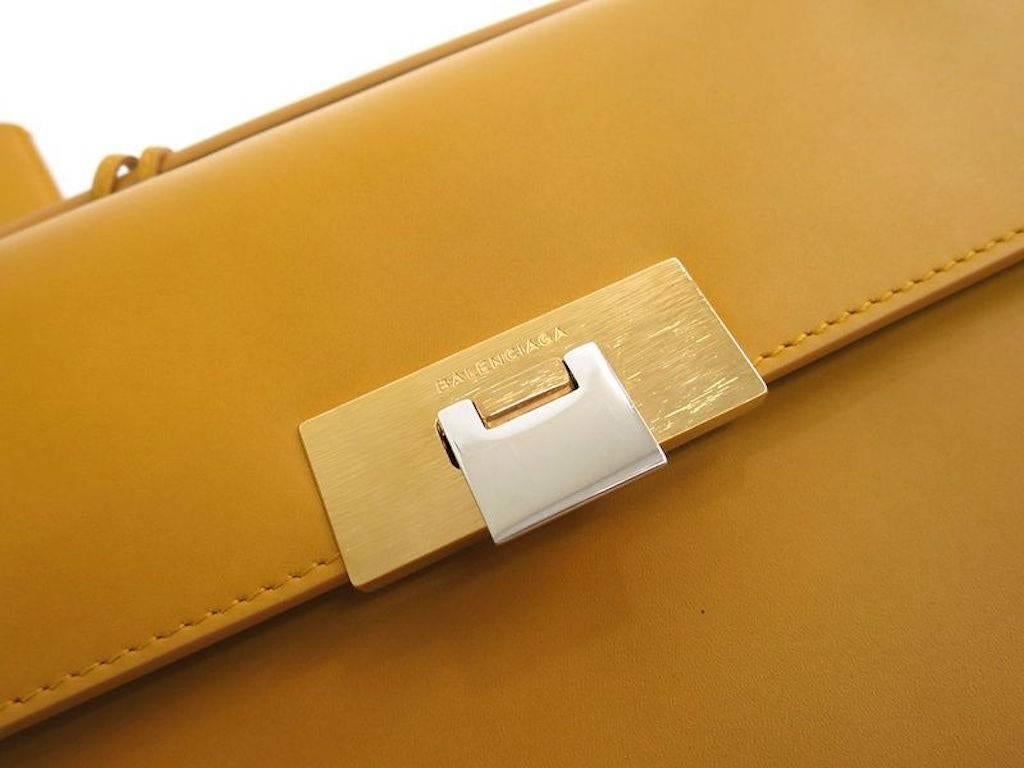 CURATOR'S NOTES

Balenciaga Yellow Leather Kelly Style Top Handle Satchel Flap Bag  

Leather
Gold hardware 
Made in Italy
Measures 12" W x 6.5" H x 2.5" D
Handle 11.5"
Includes original Balenciaga dust bag and charm